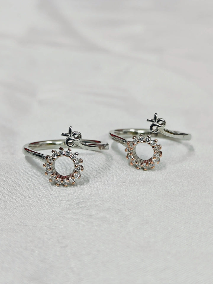 Pair of silver earrings with circular designs on a light gray background