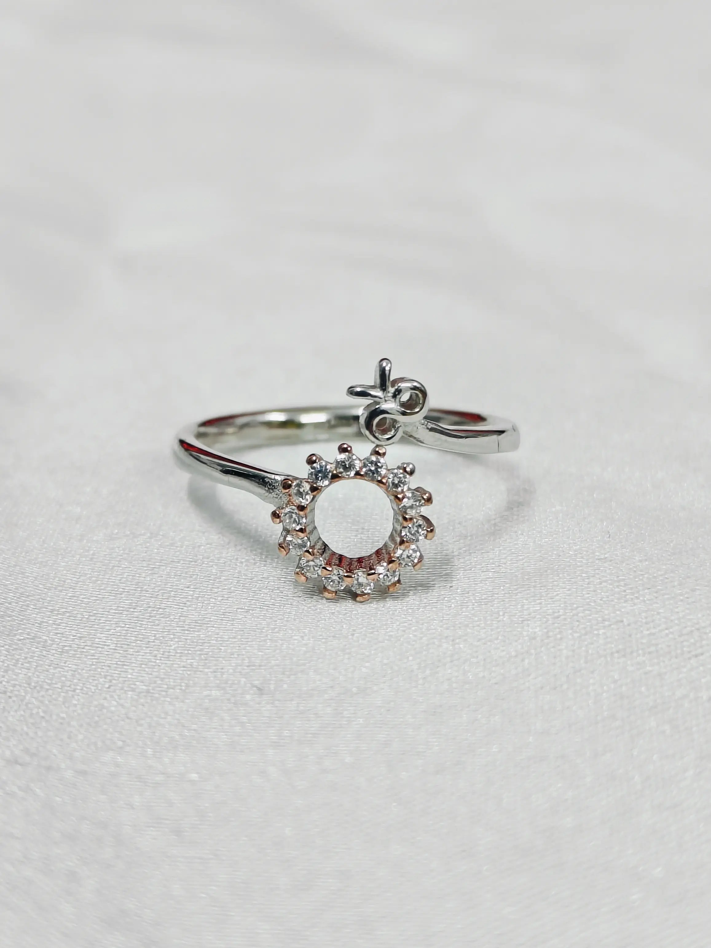 Silver ring with a decorative design on a light gray background