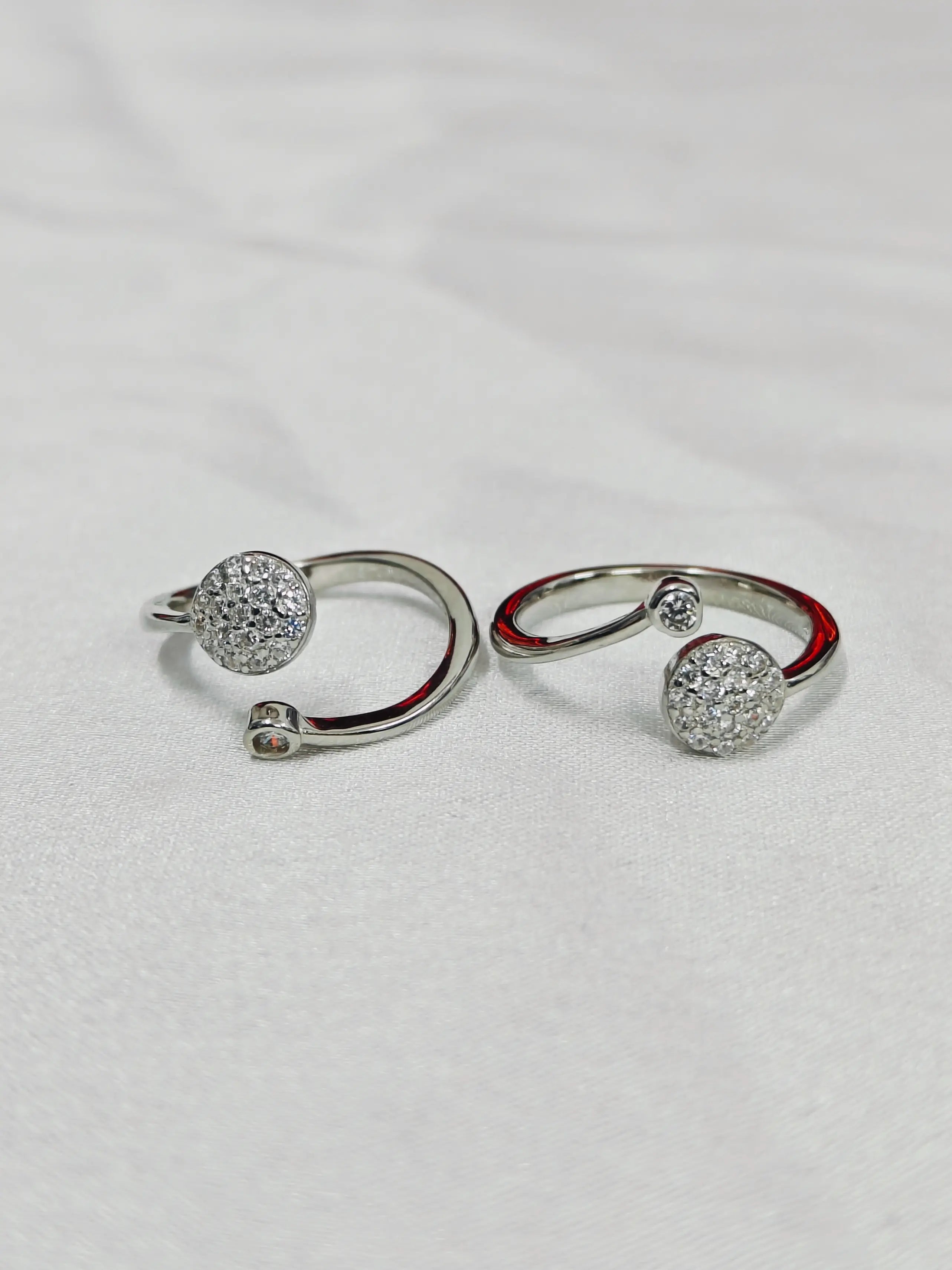 Pair of silver hoop earrings with round embellishments on a light gray background