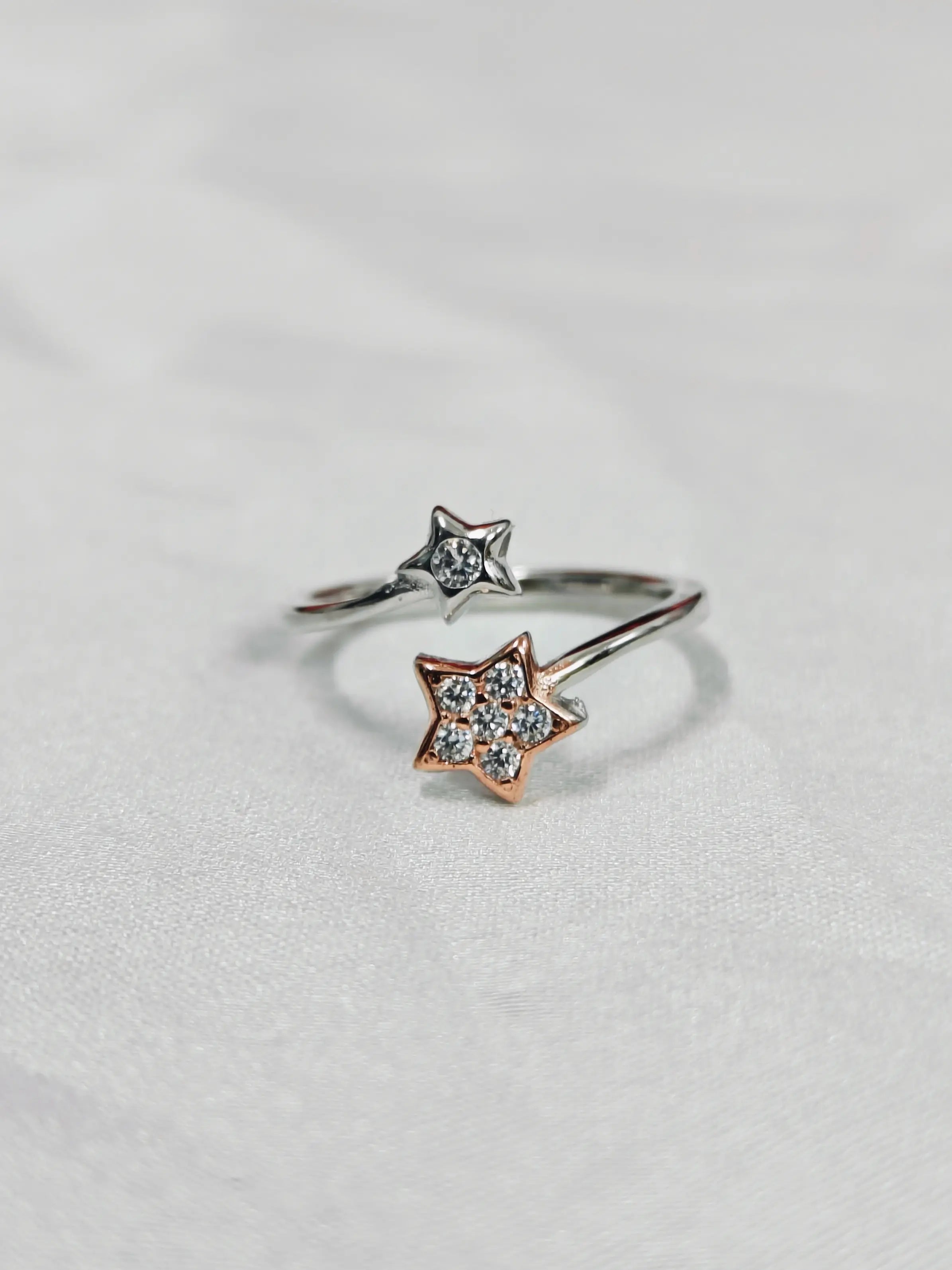 Star-shaped ring with diamond accents on a light gray background