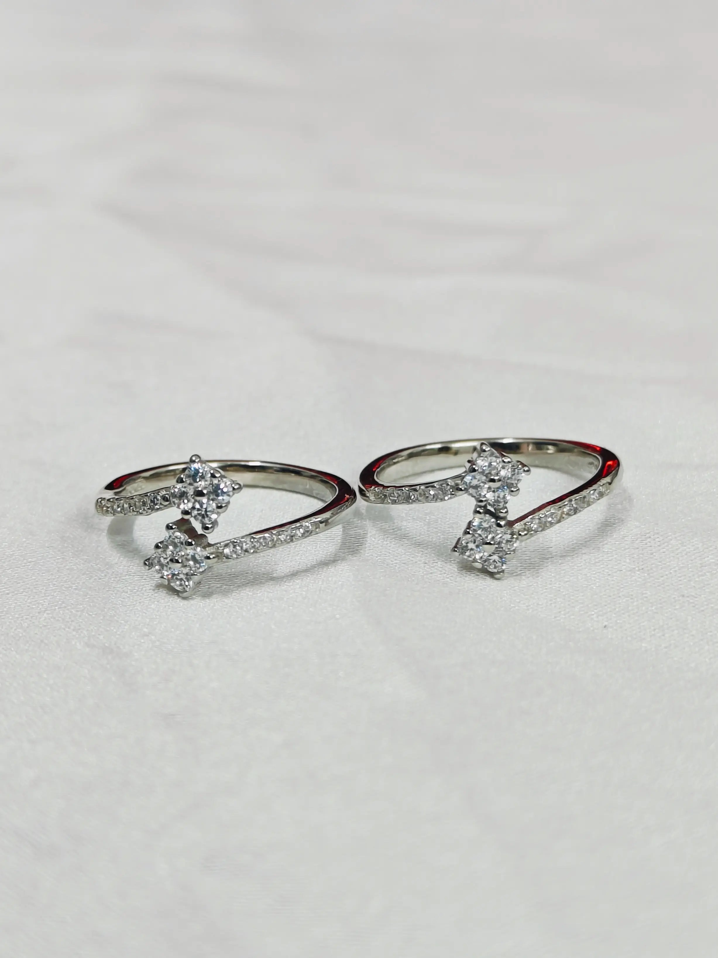 Two silver rings with gemstones on a light gray background