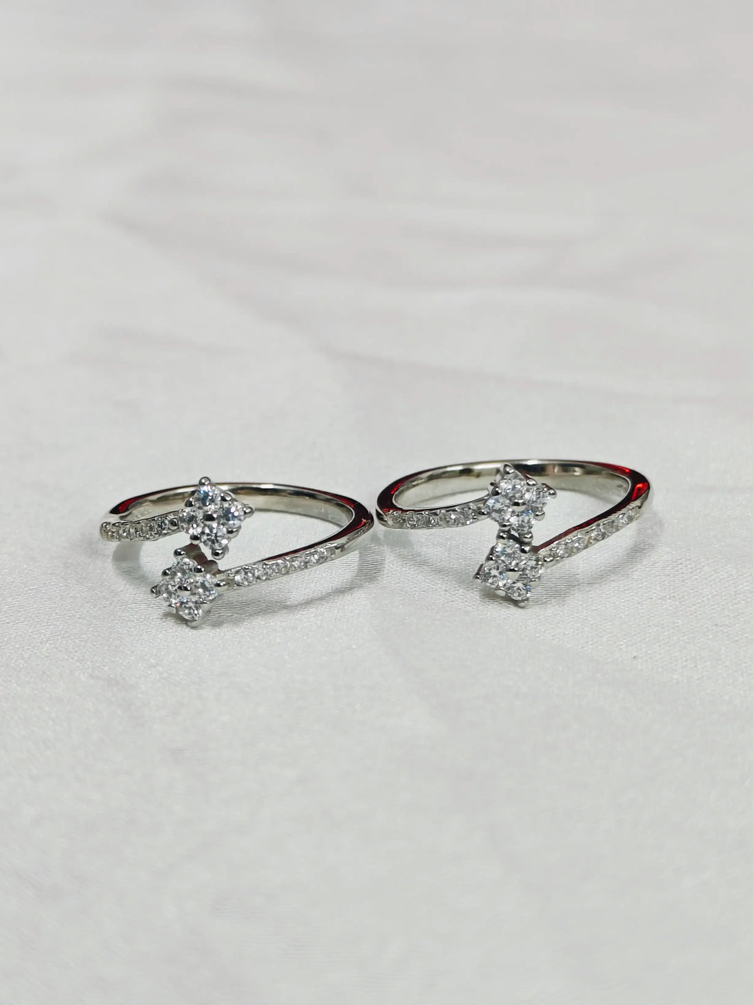 Two silver rings with gemstones on a light gray background