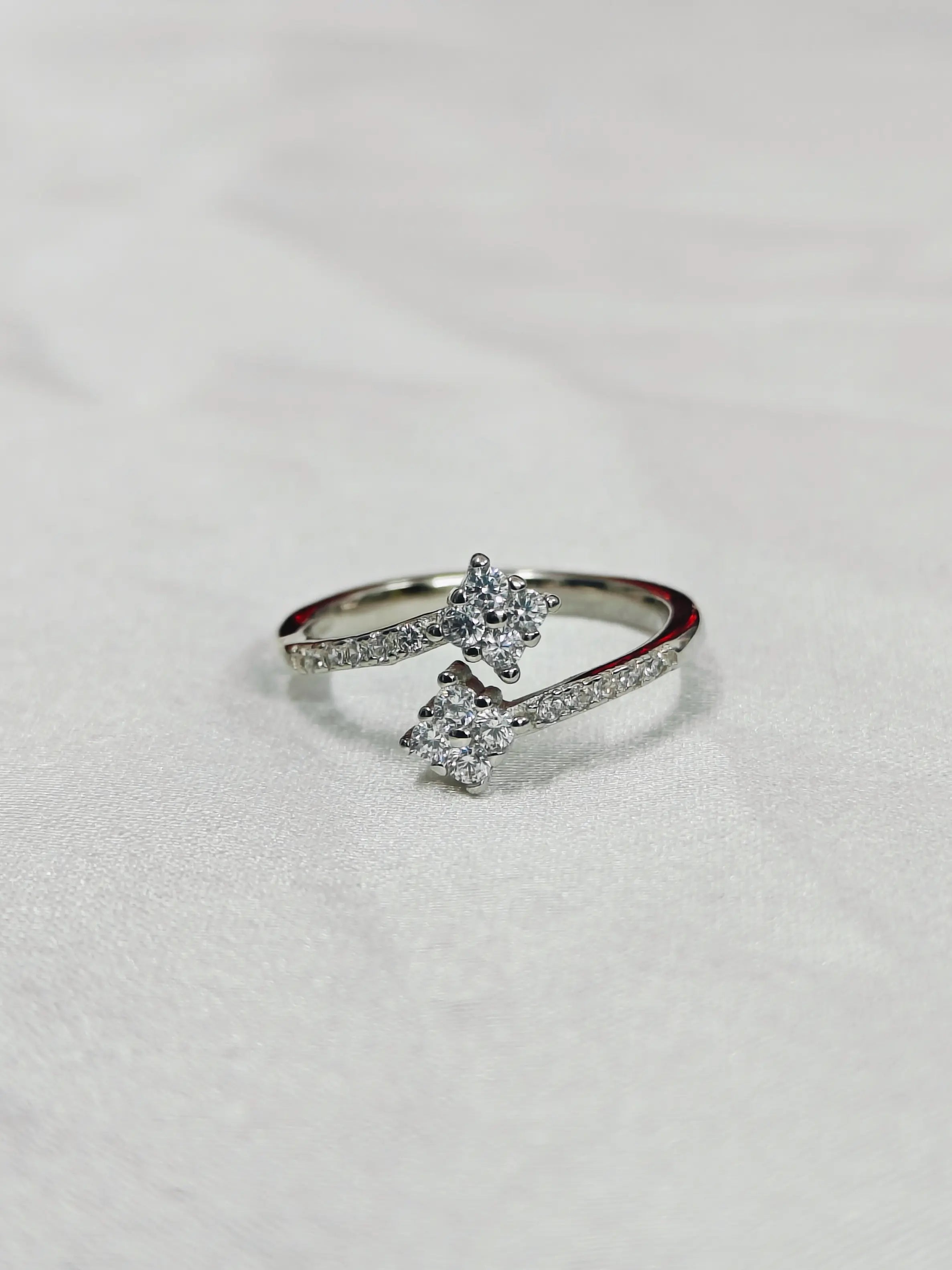 Silver ring with diamond accents on a light gray background