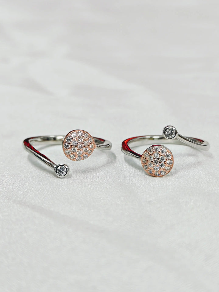 Pair of silver open rings with round gemstones on a light gray background