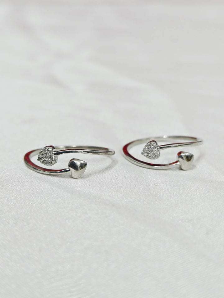 Pair of silver open rings with small stones on a light gray background