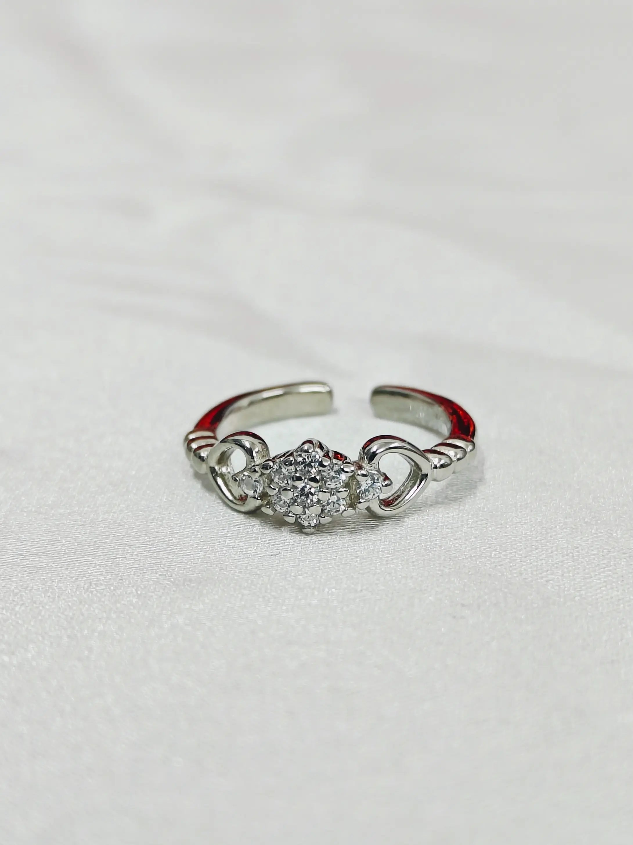 Silver ring with gemstones on a light gray background