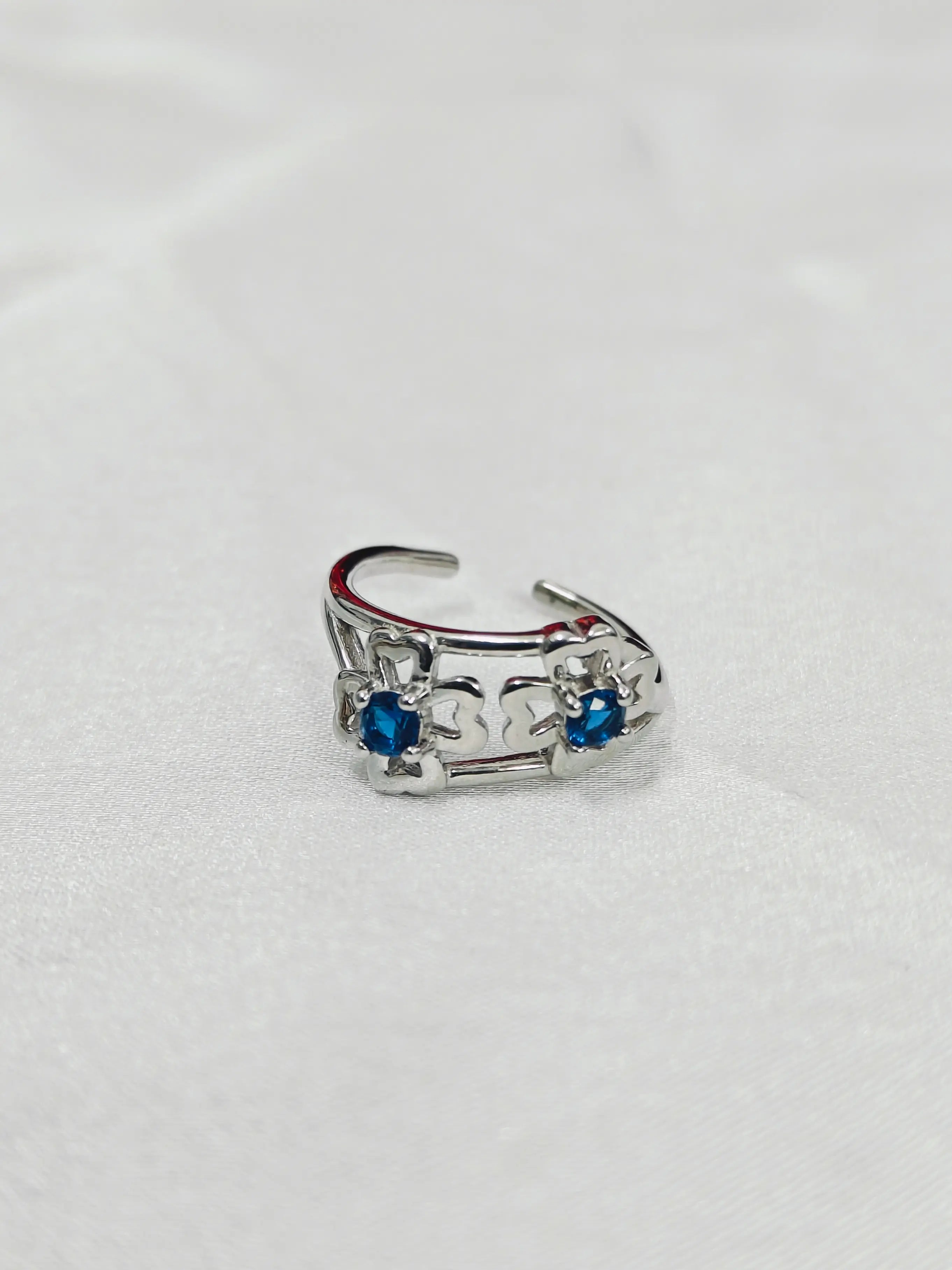 Silver ring with blue gemstones on a white background