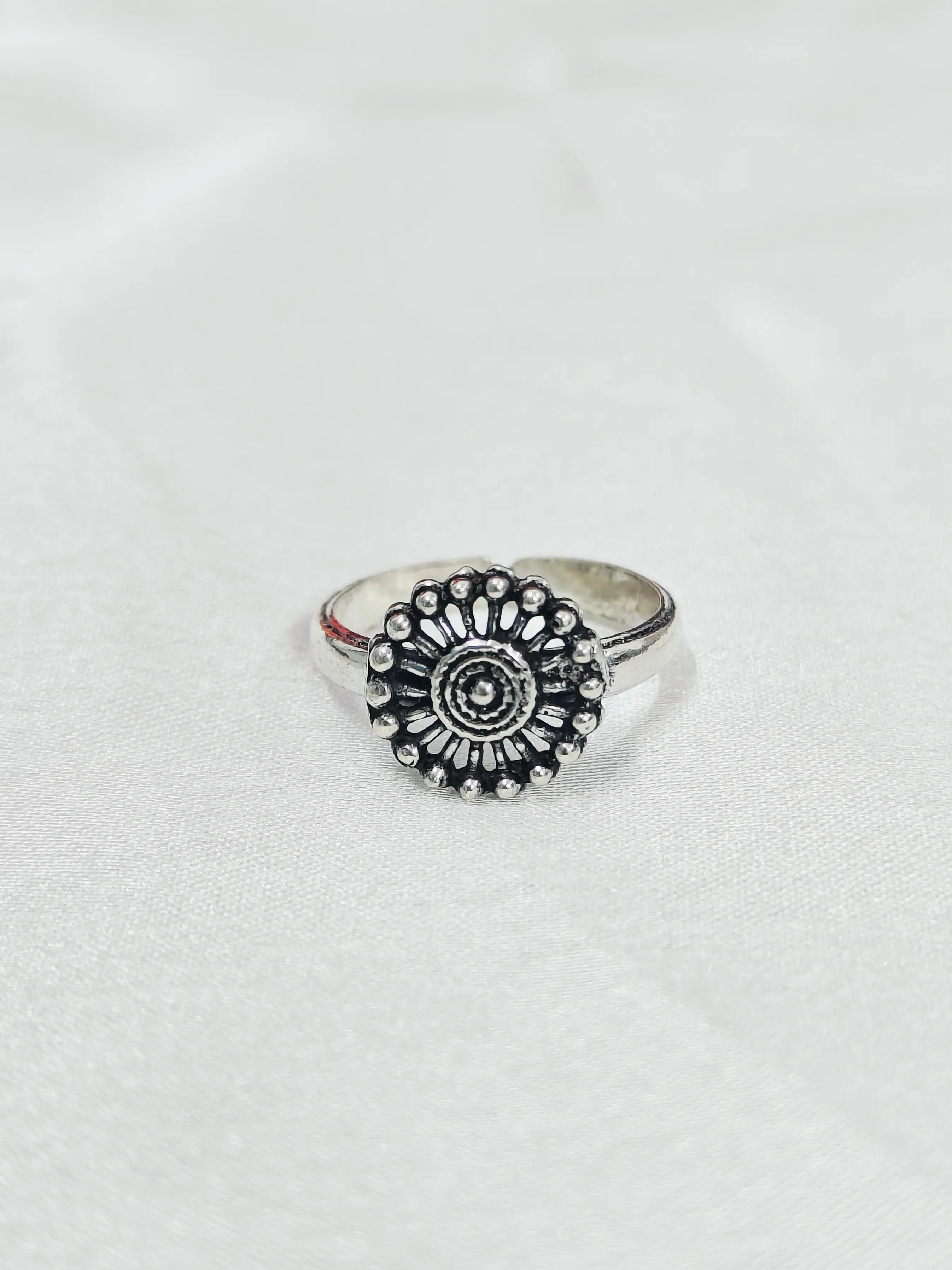 Silver ring with a decorative design on a white background