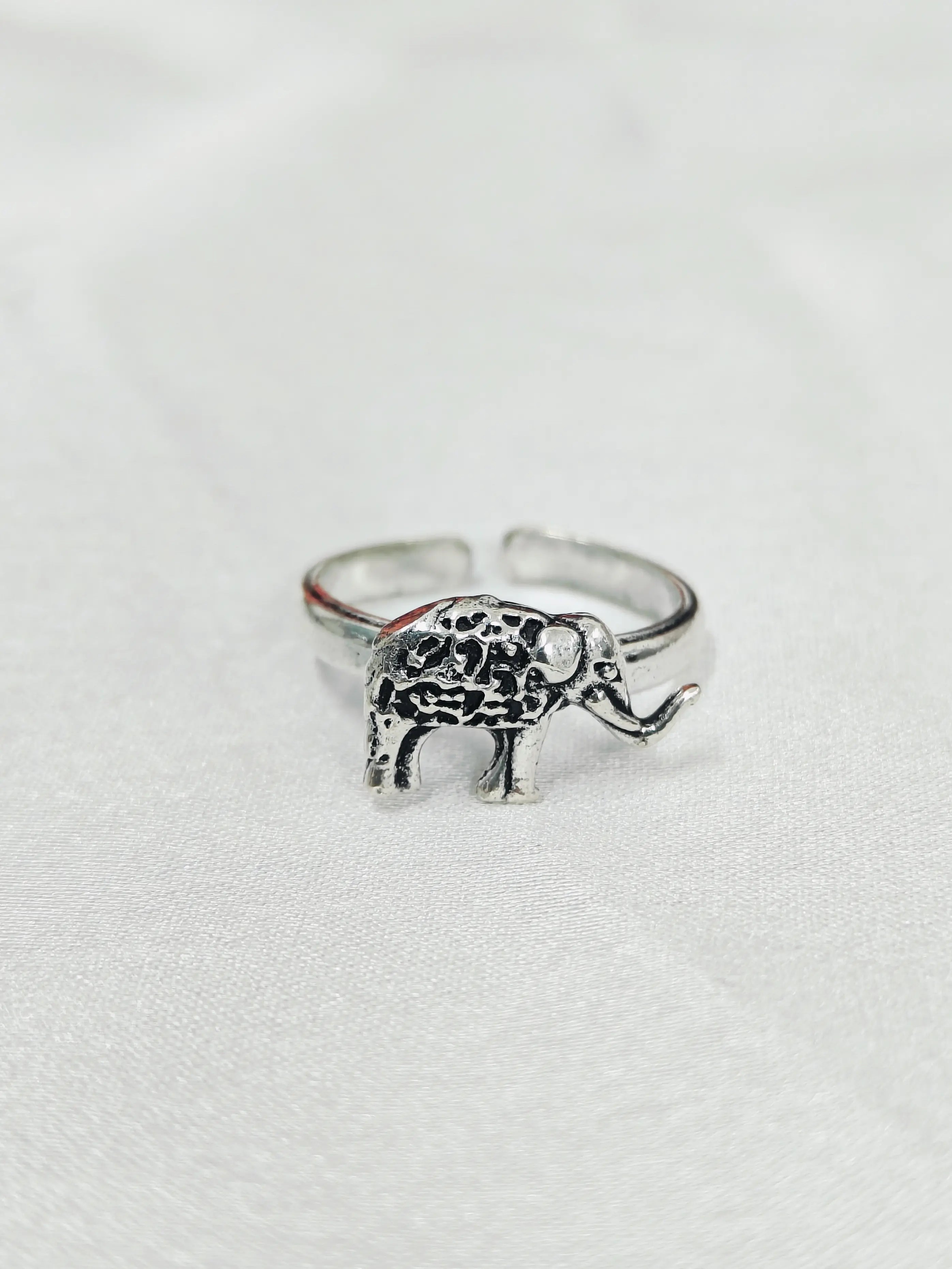 Silver elephant ring on a light gray background