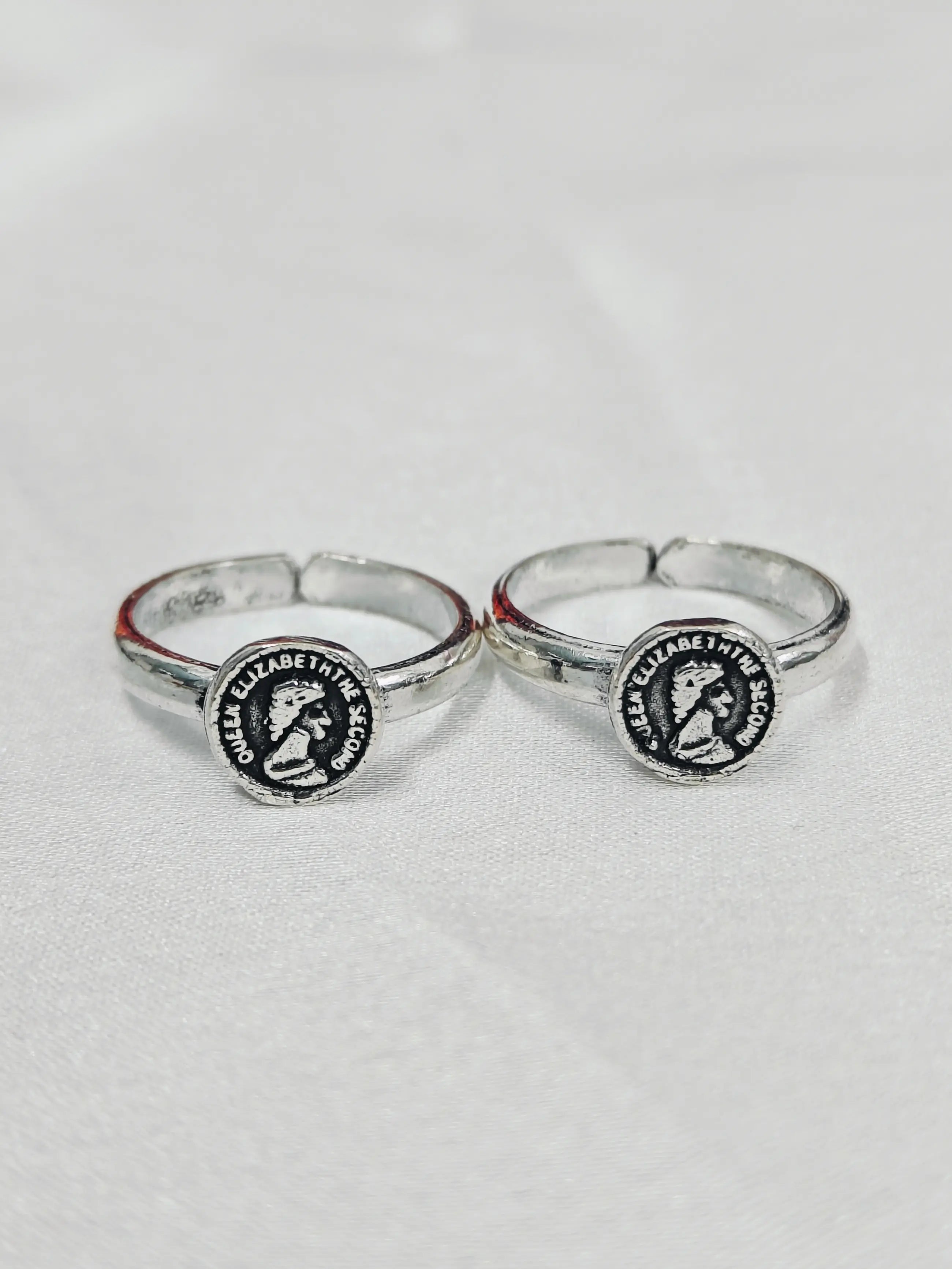 Two silver rings with circular designs on a light gray background