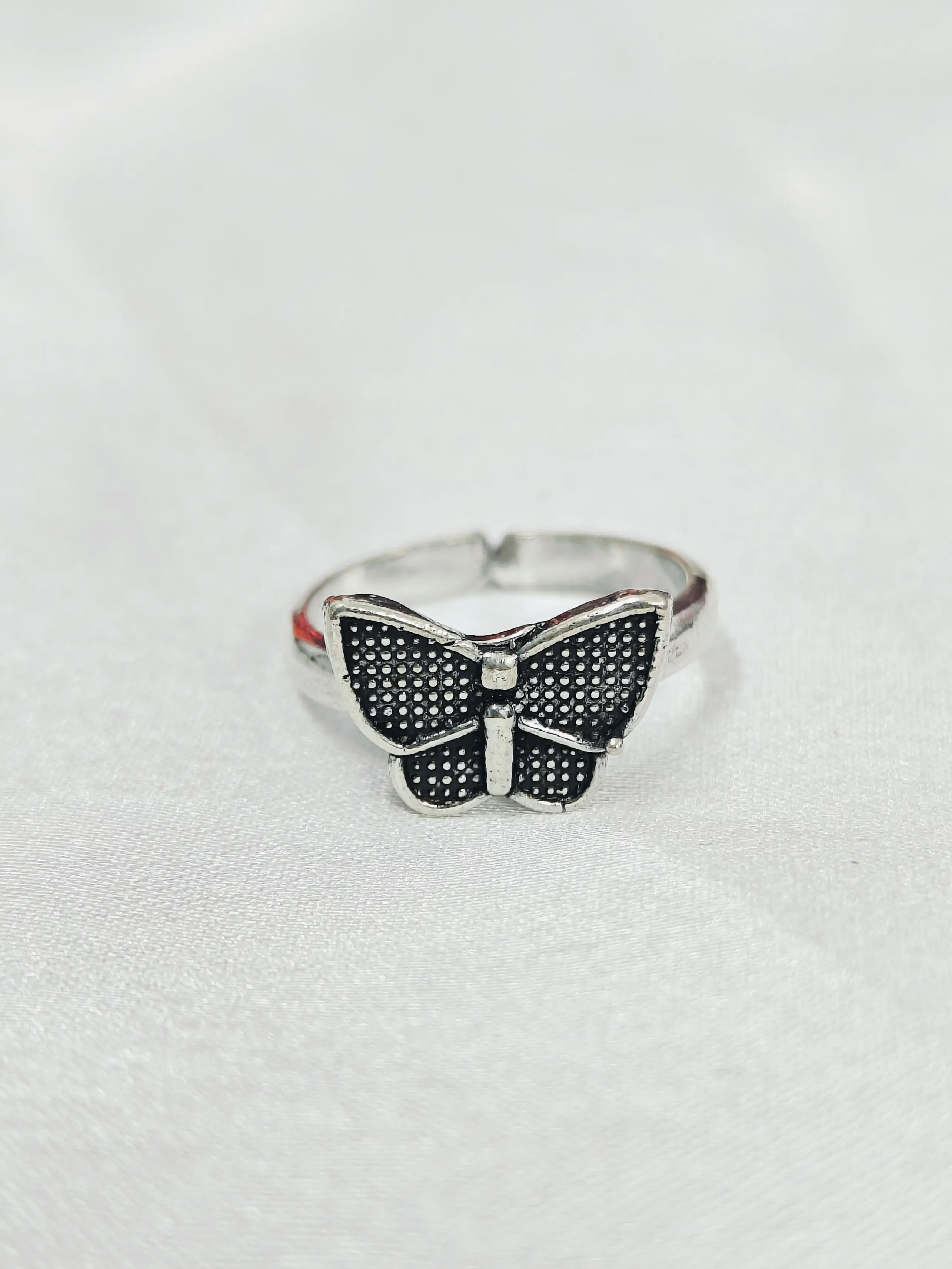 Butterfly-shaped ring on a light gray background