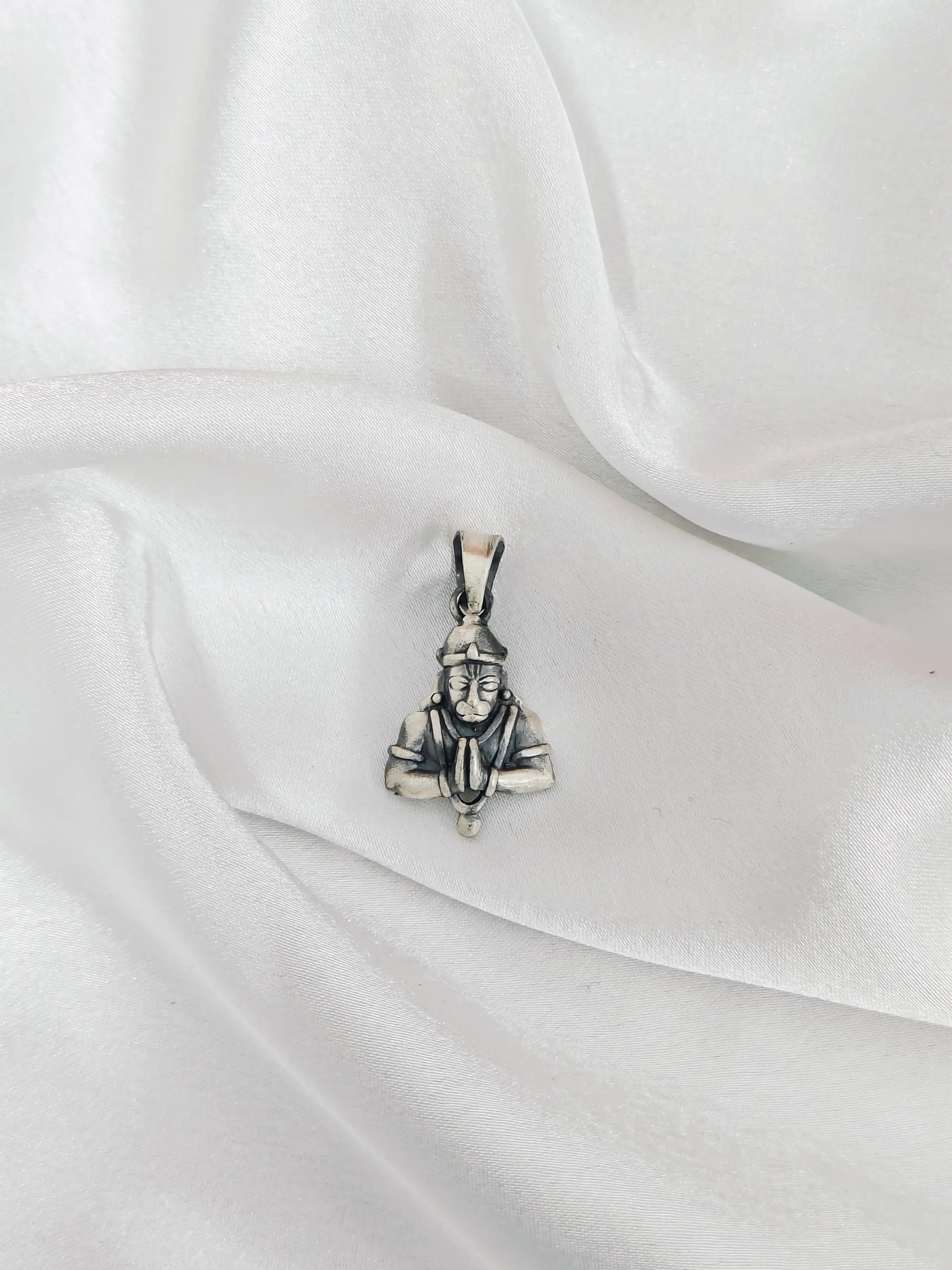 Silver pendant on a white fabric background