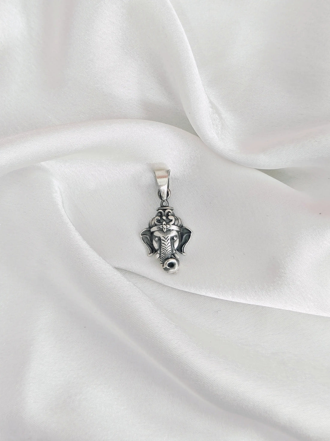 Silver pendant on a white satin fabric
