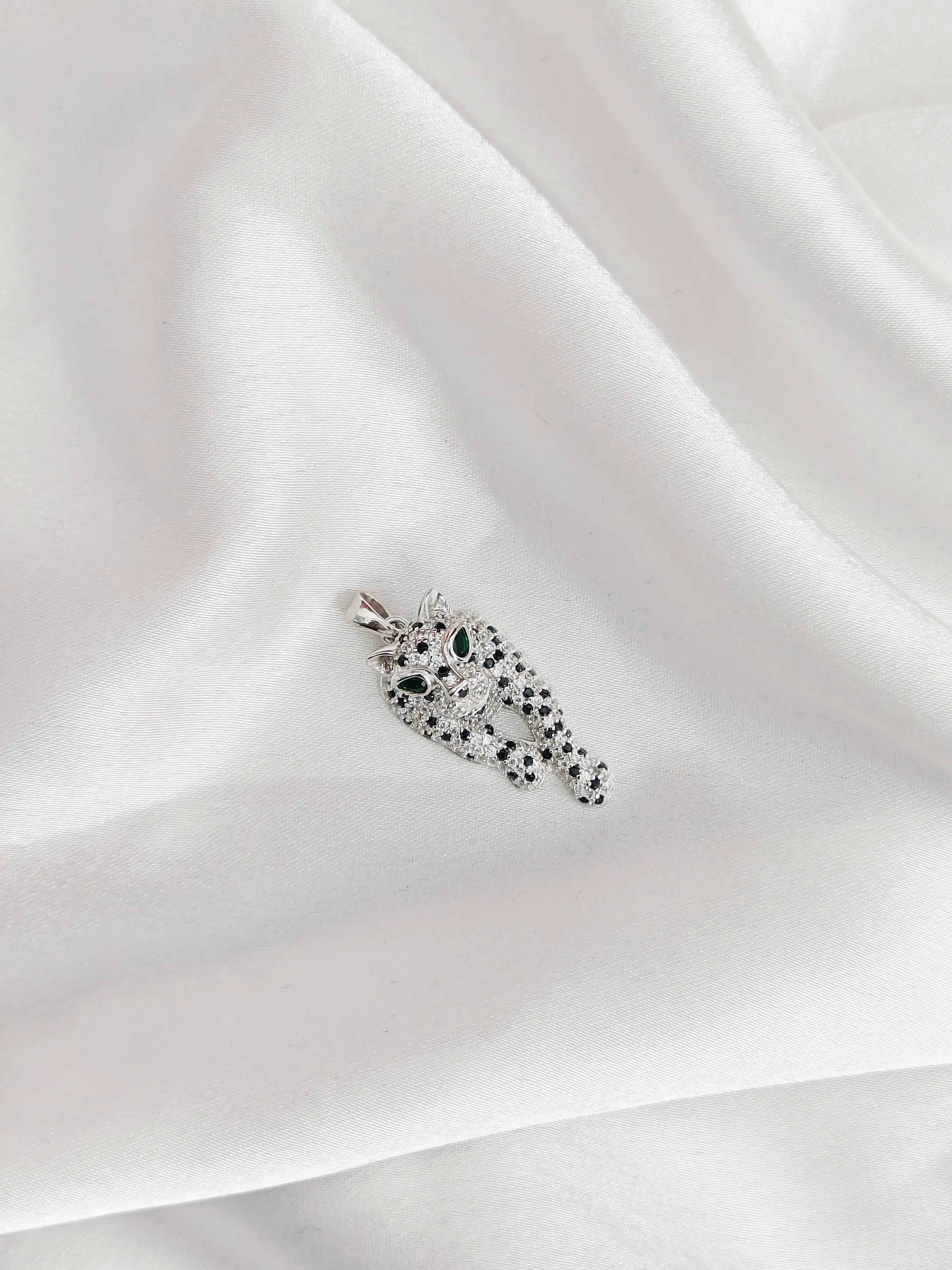 Elegant necklace with green gemstones on a white fabric background