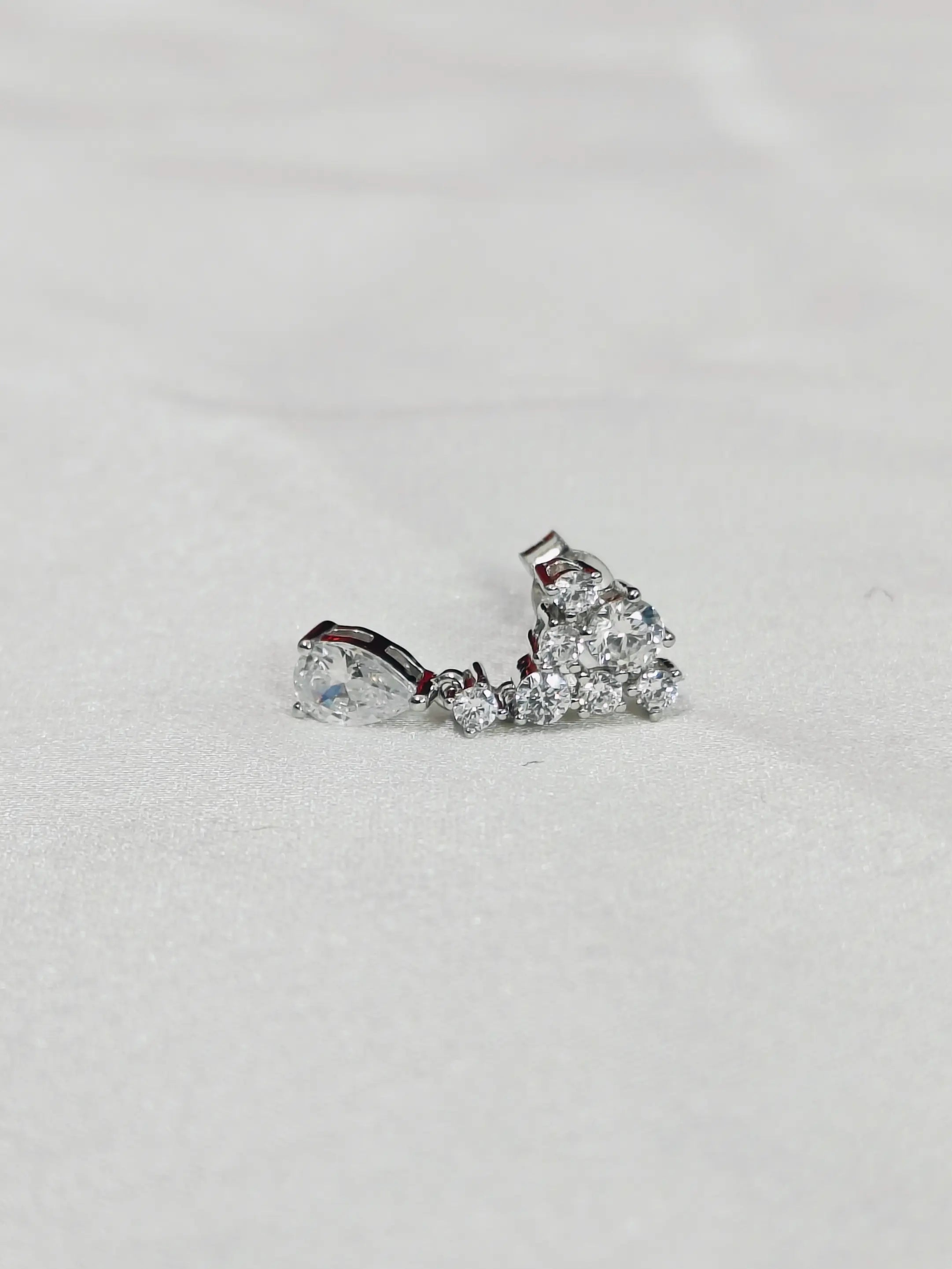 Pair of diamond earrings on a light gray background