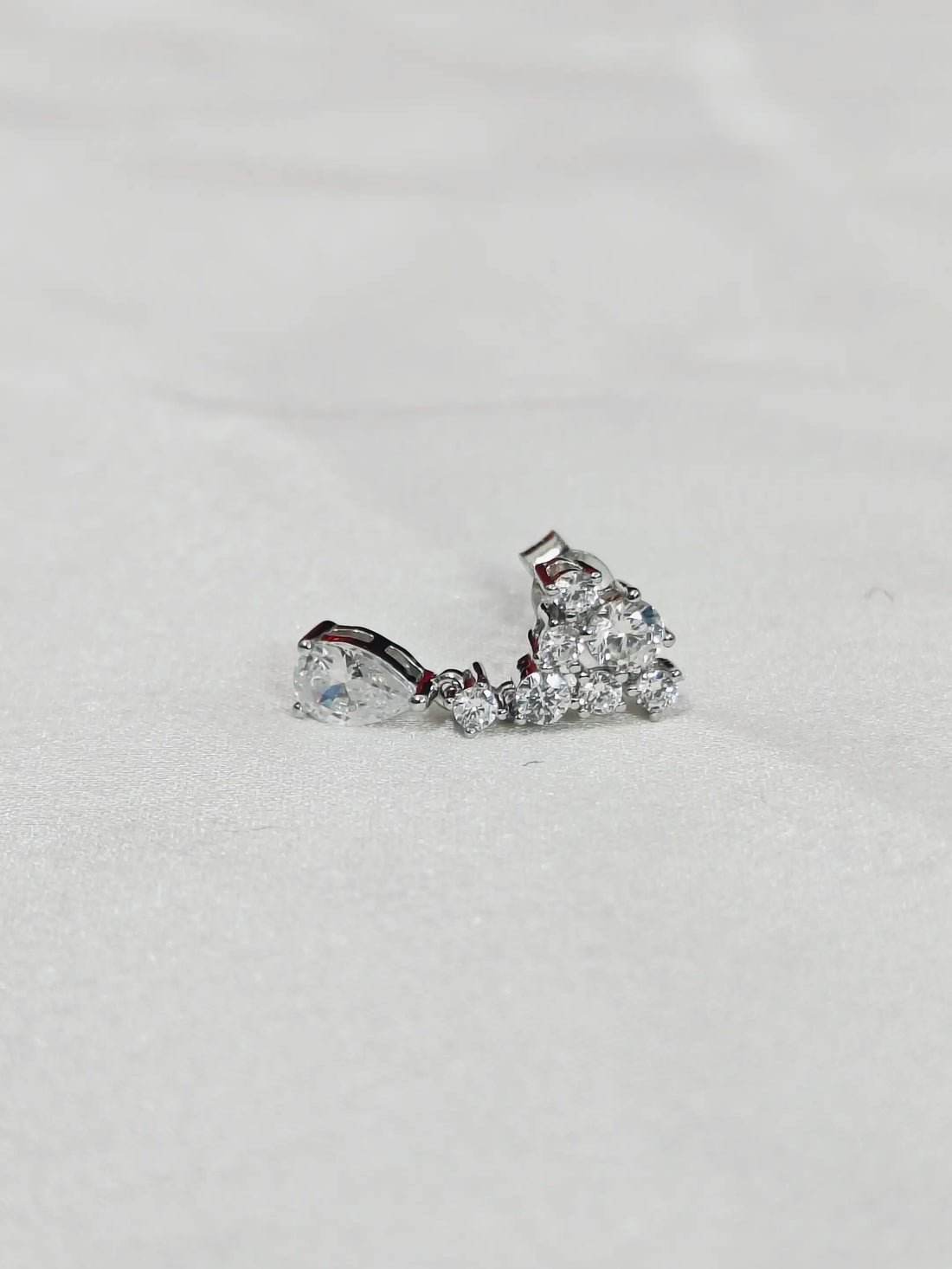 Pair of diamond earrings on a light gray background