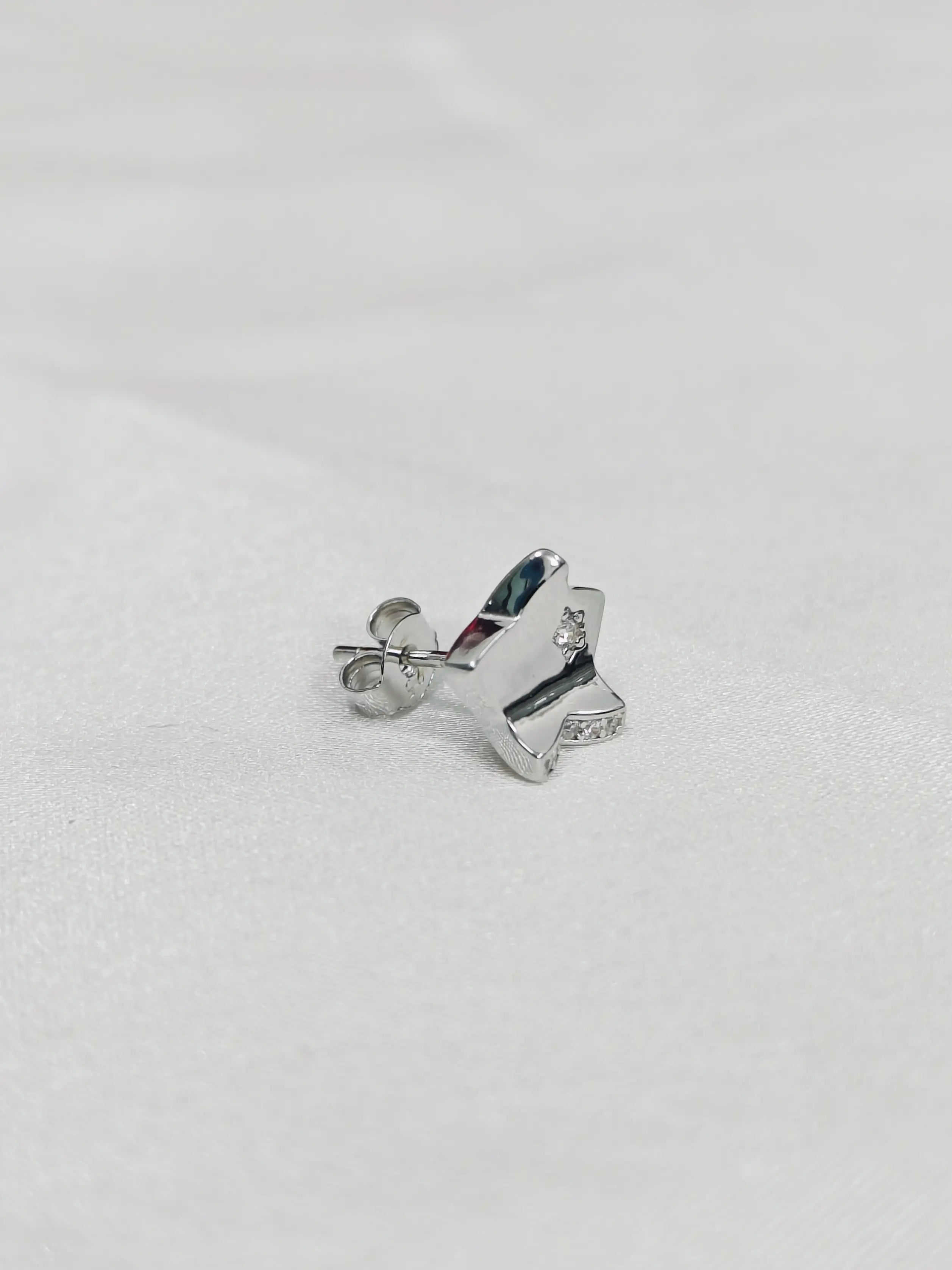 Silver butterfly-shaped earrings on a light gray background