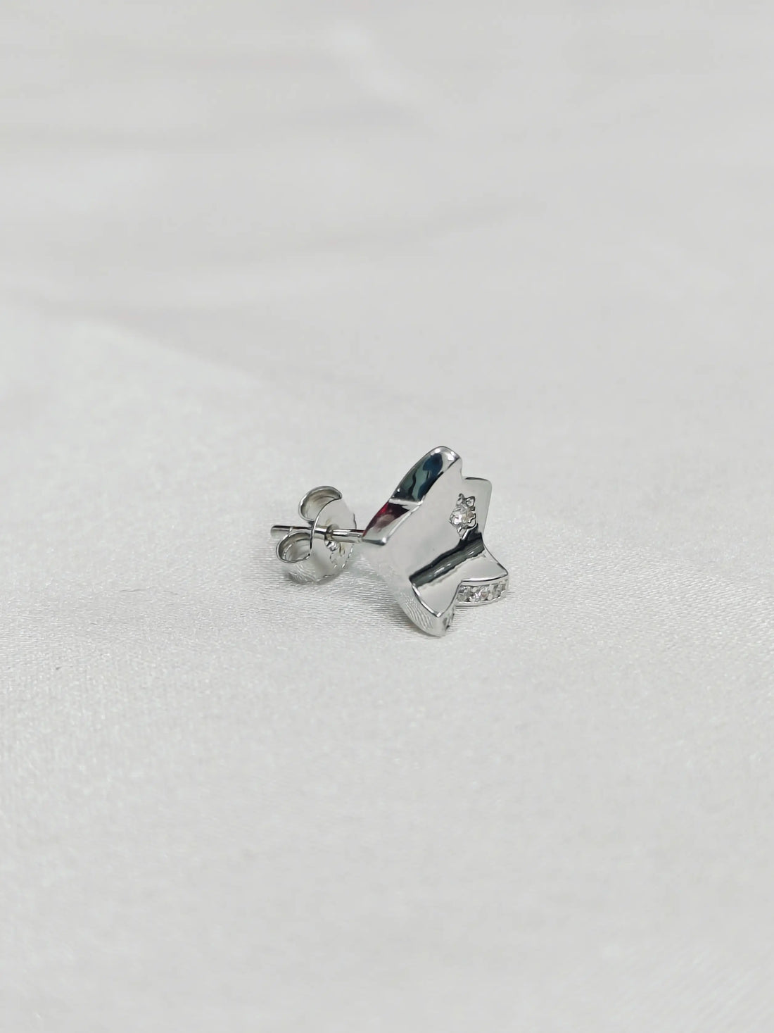 Silver butterfly-shaped earrings on a light gray background