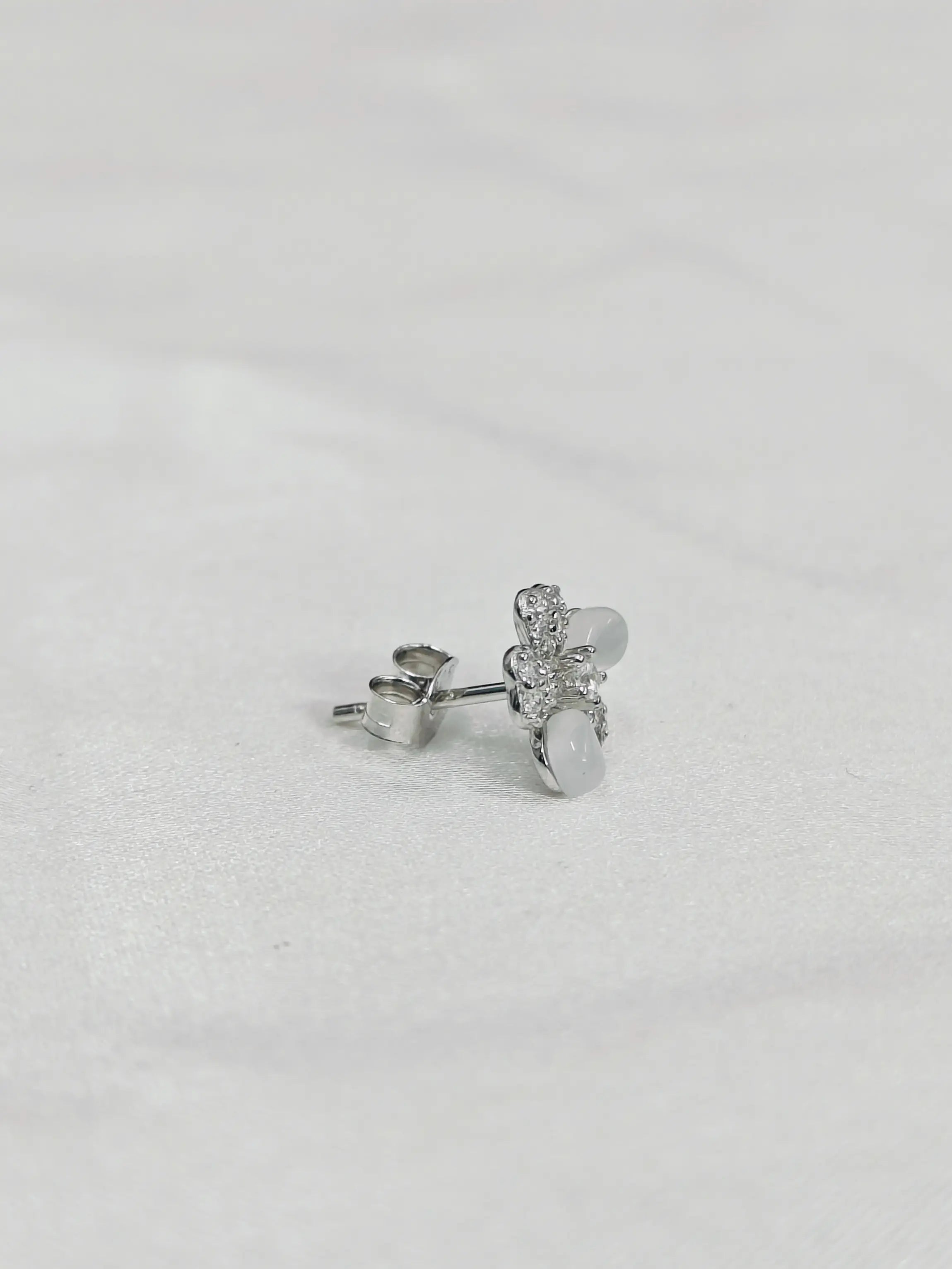 Silver earrings on a light gray background