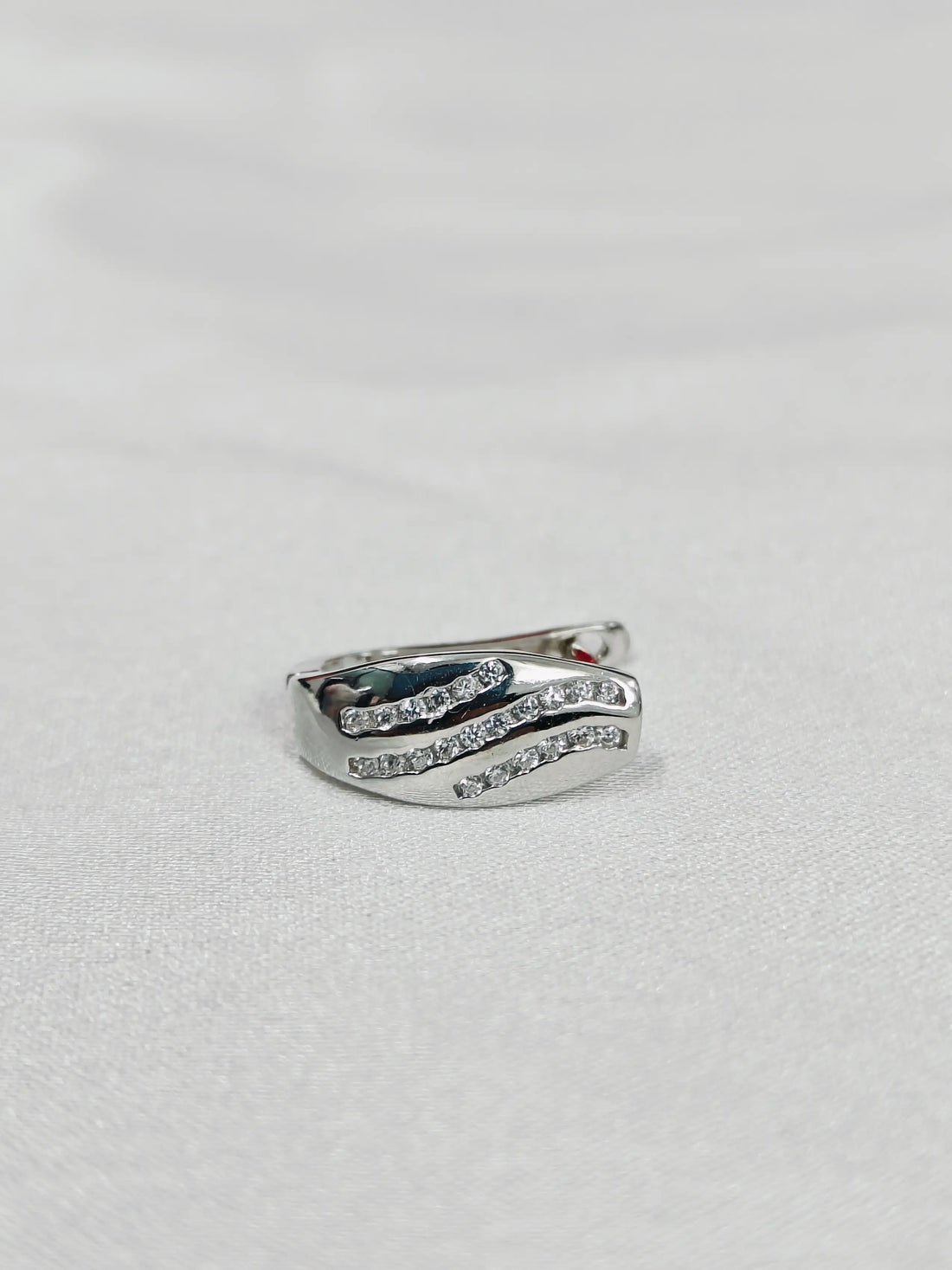 Silver ring with gemstone on a light gray background