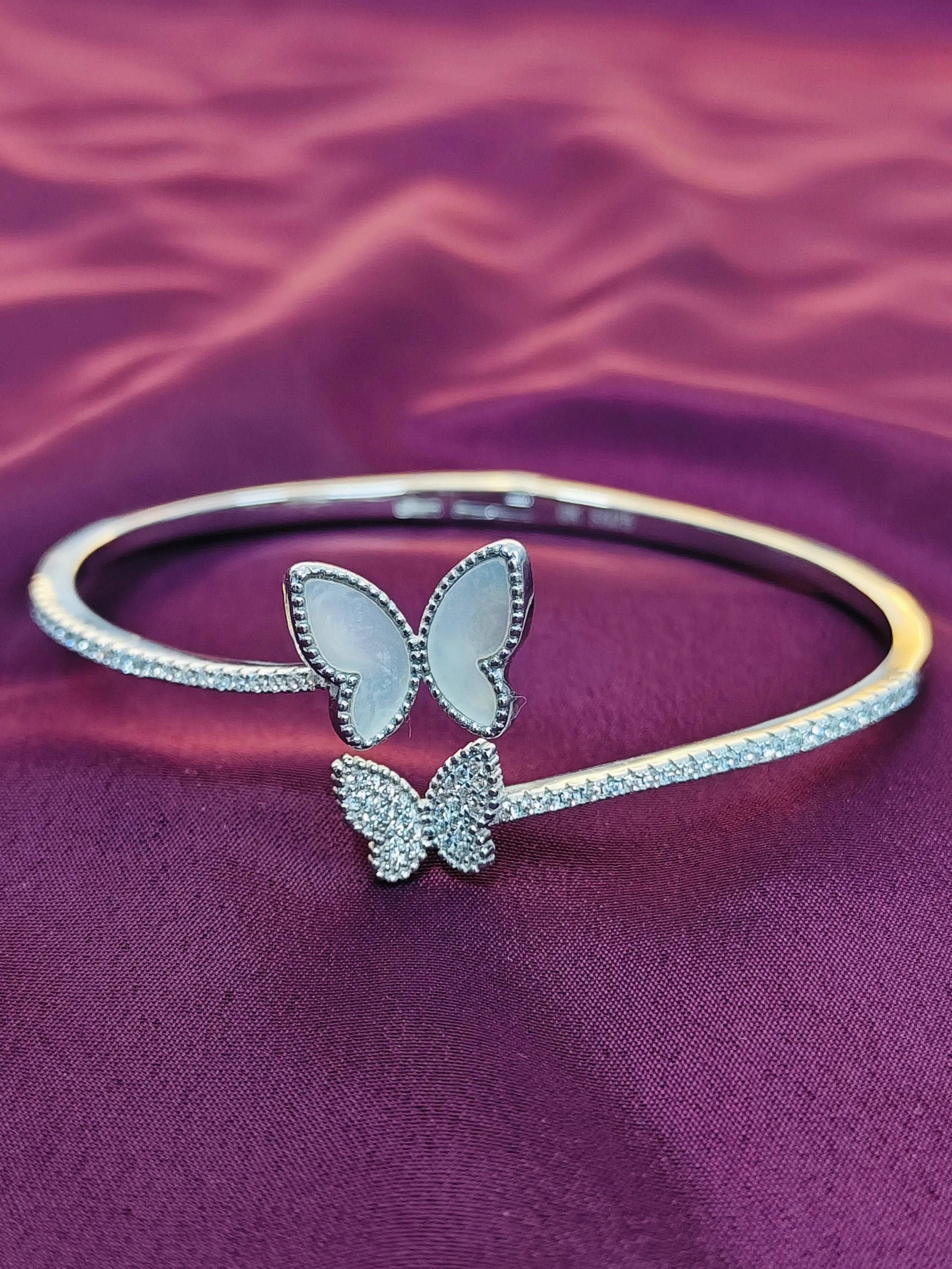 Silver butterfly bracelet on a purple fabric background