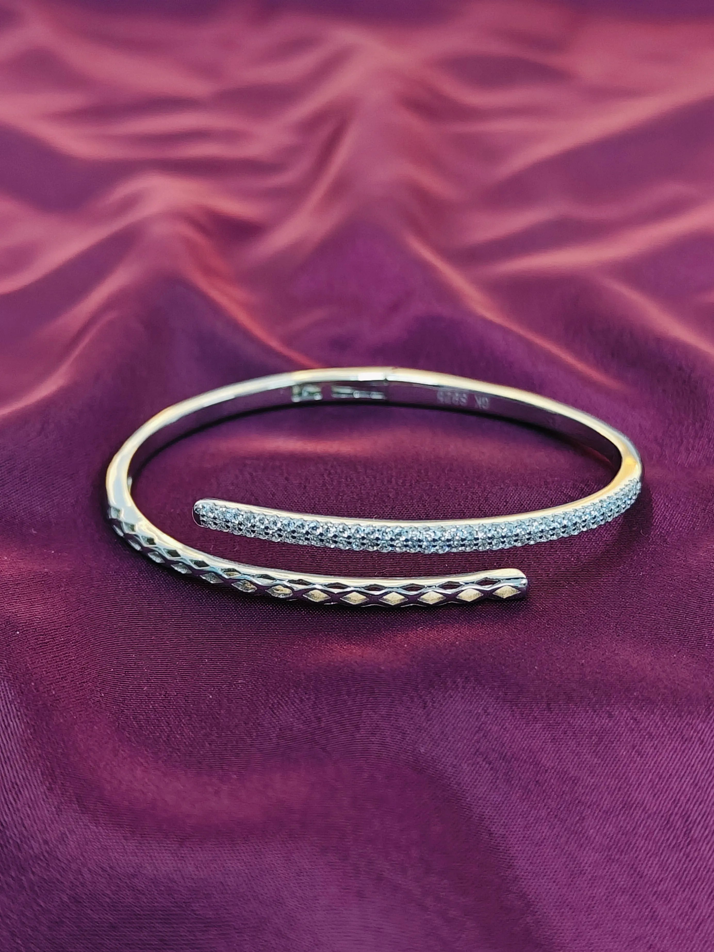 Silver bracelet on a purple fabric background