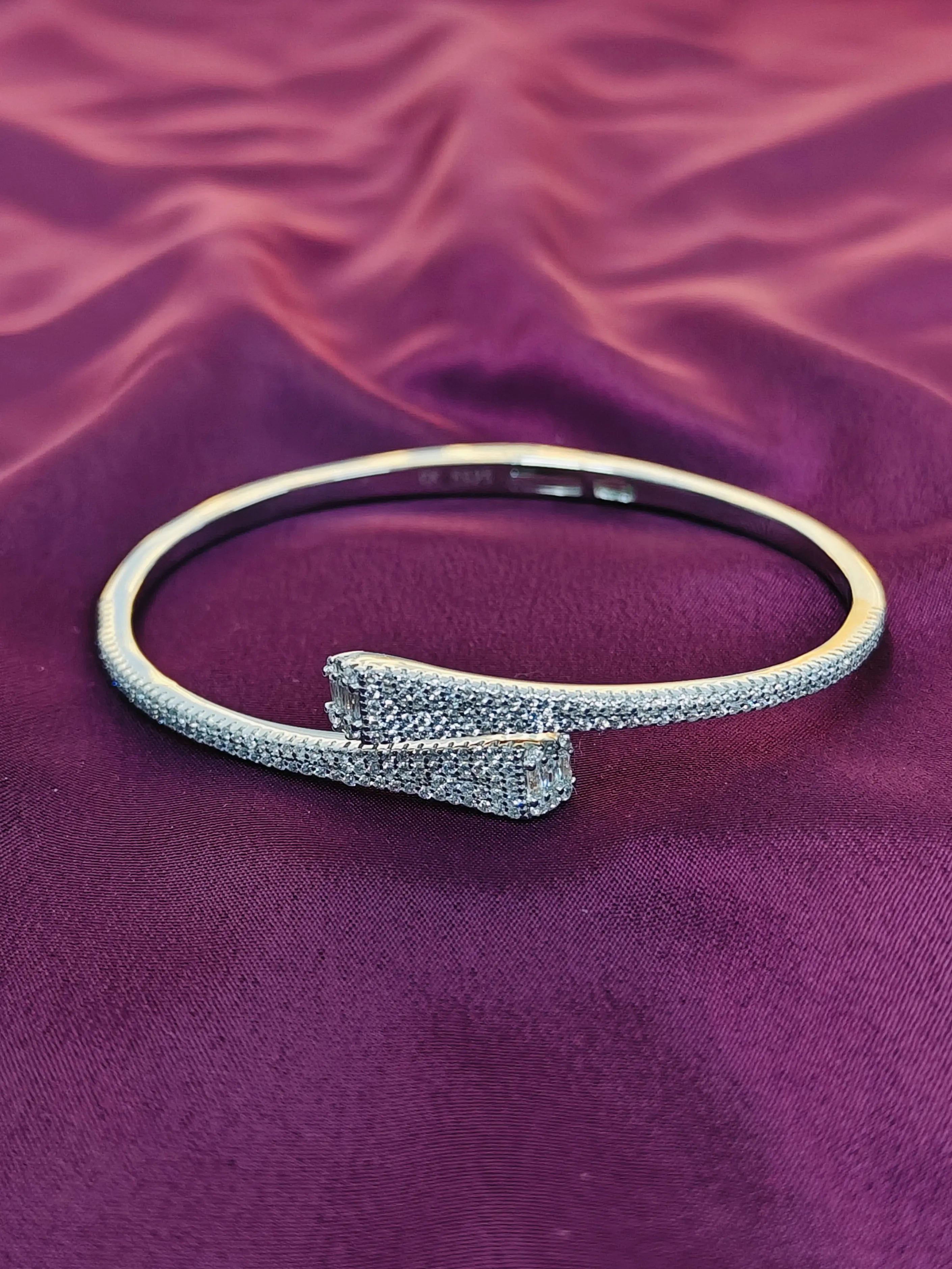 Silver bracelet on a purple fabric background