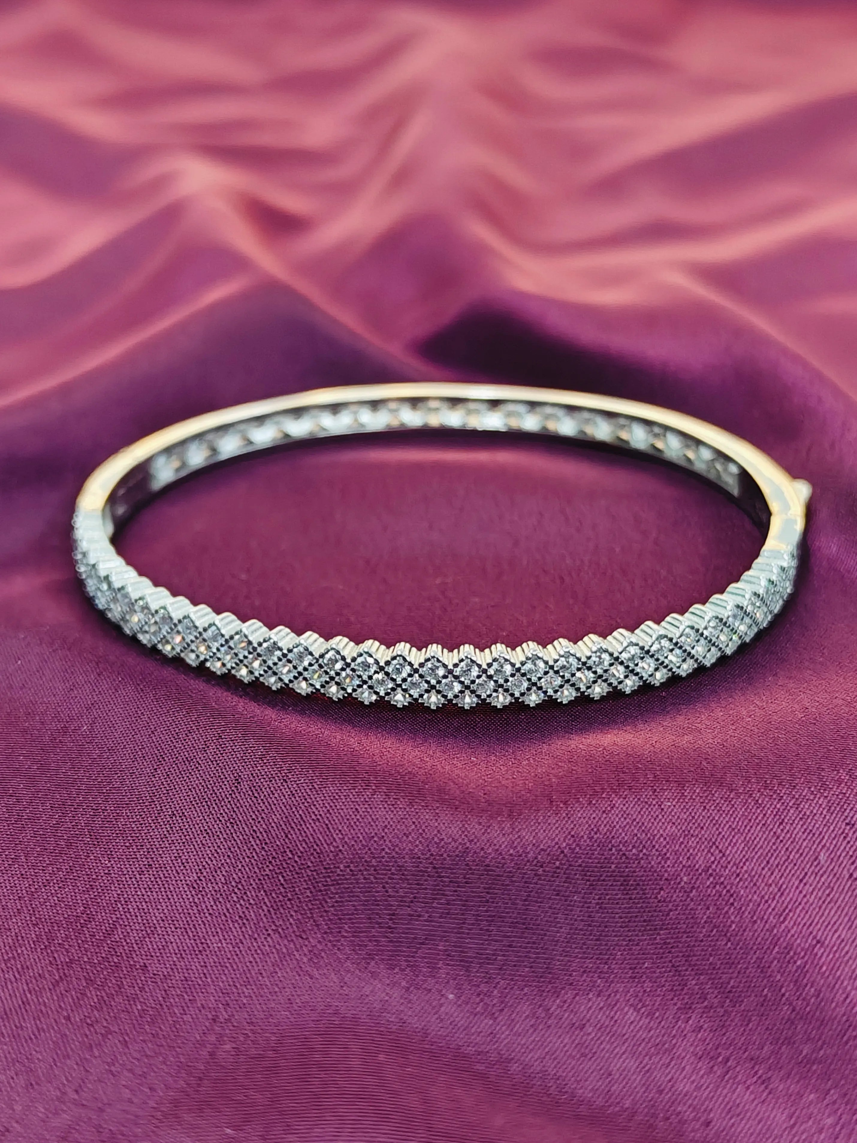 Silver bracelet on a purple fabric background
