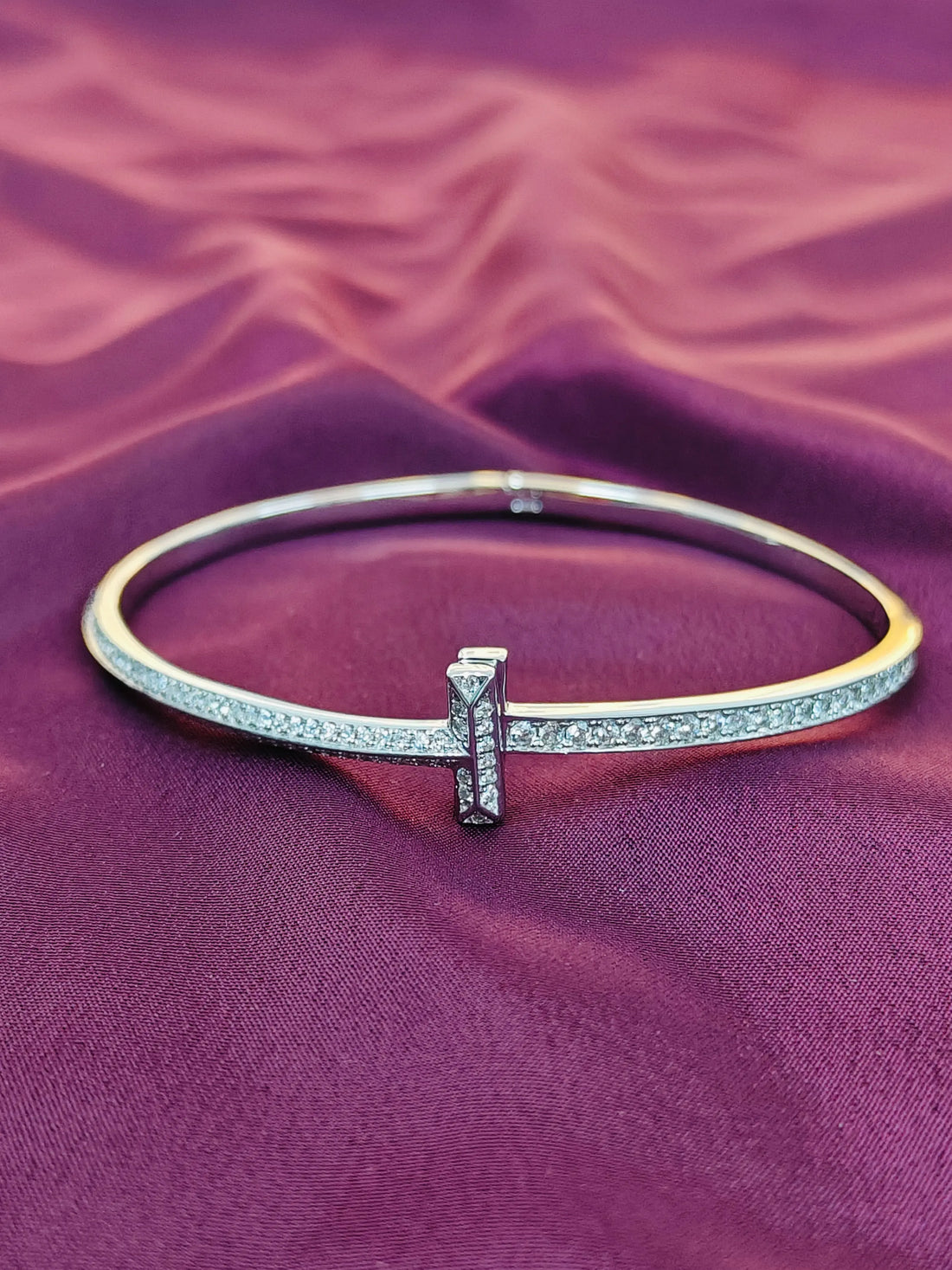 Gold and silver bracelet on a purple fabric background