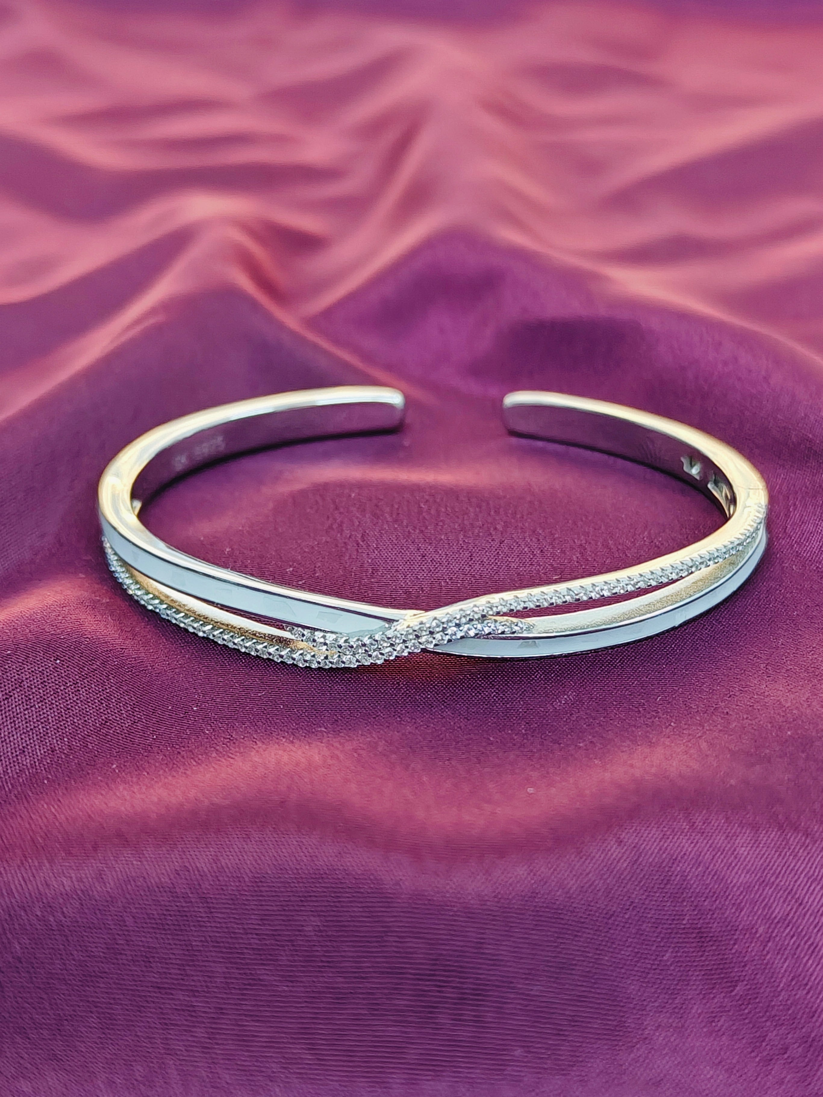 Silver bracelet on a purple fabric background