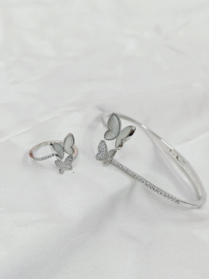 Silver butterfly-themed ring and bracelet on a white background