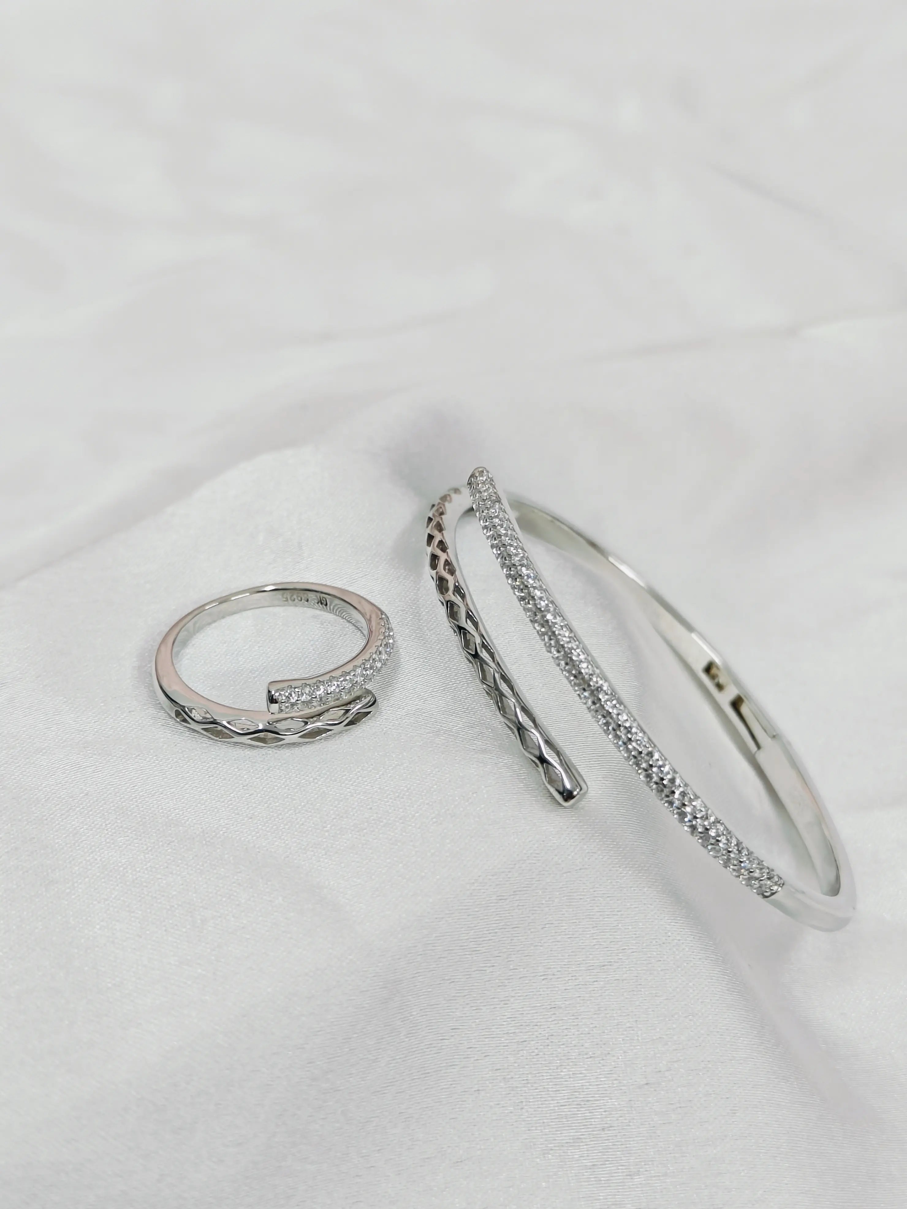 Silver ring and bracelet set on a white surface