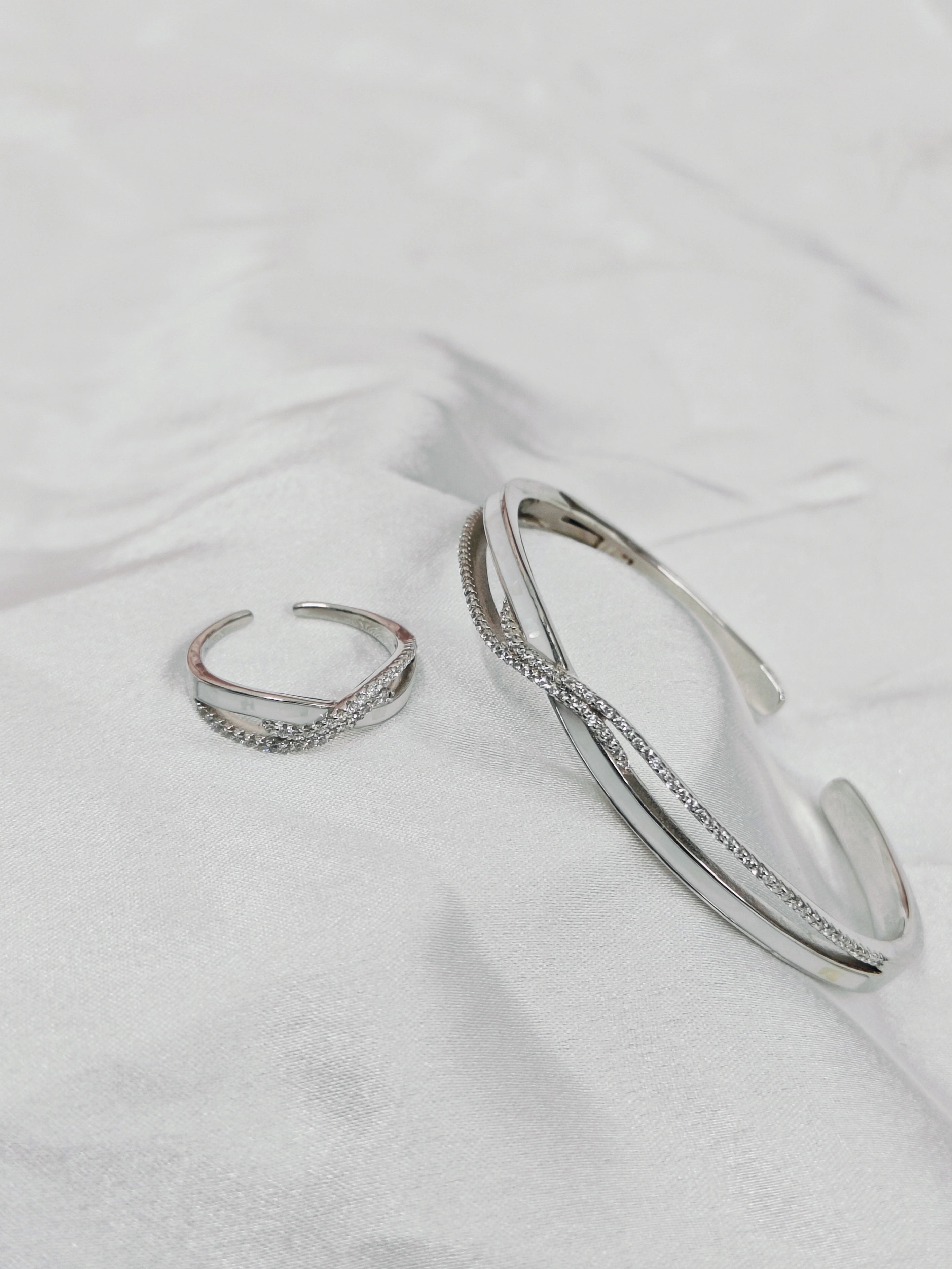 Silver hoop earrings on a white fabric background