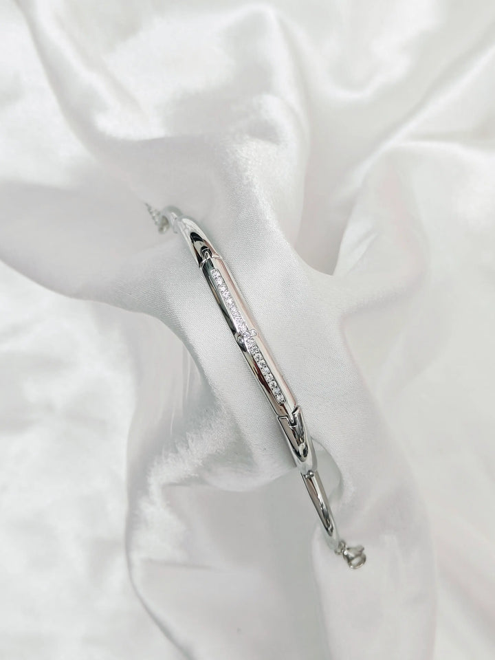 Silver bracelet with crystals on a white fabric background