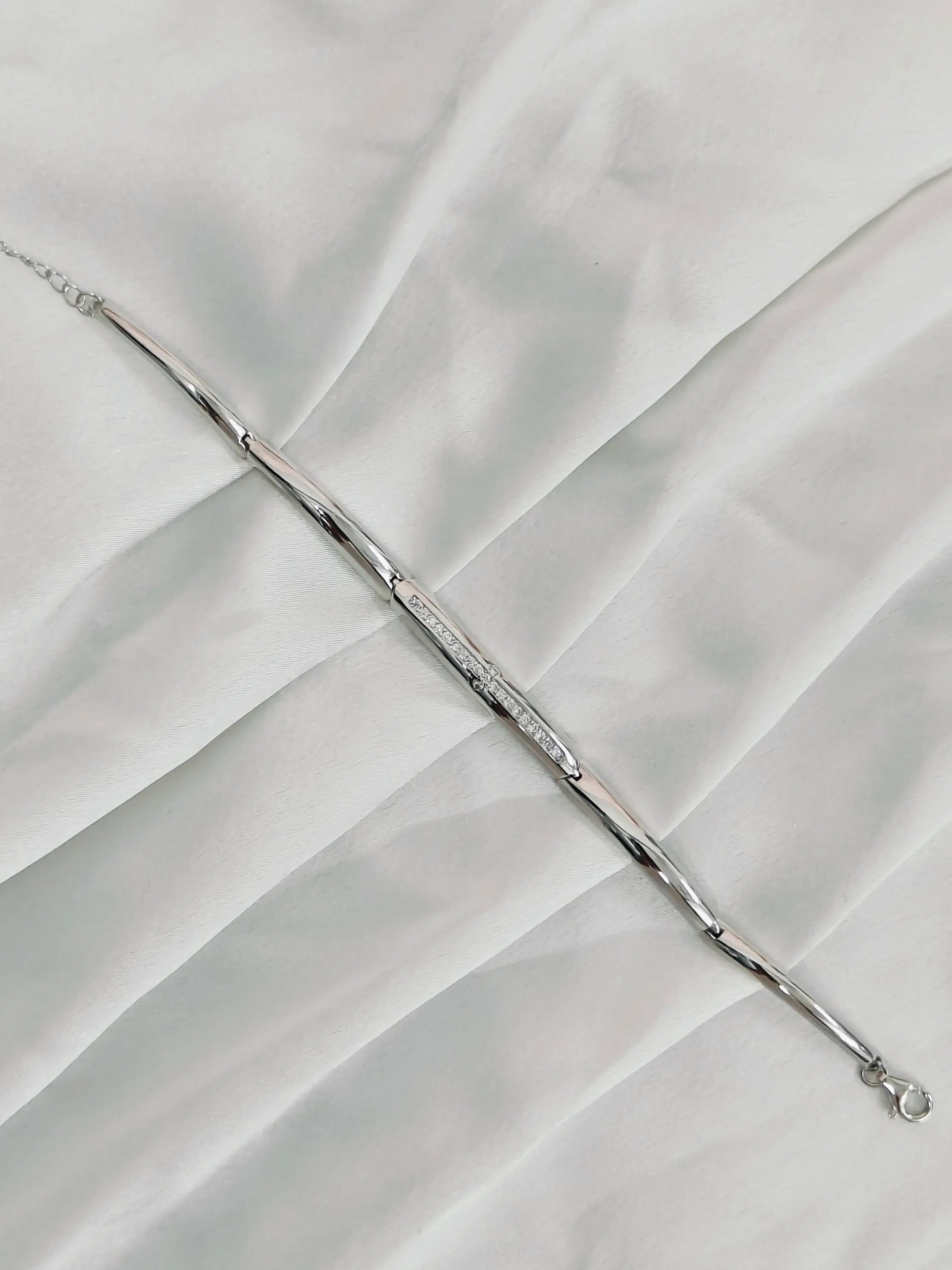 Silver bracelet on a white fabric background