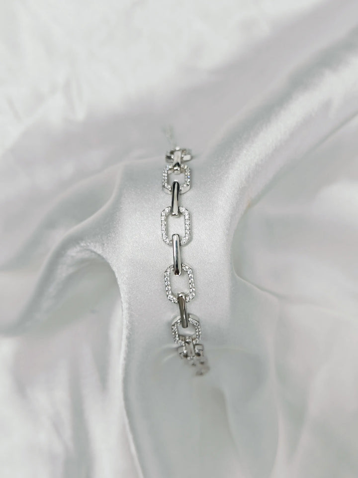 Silver bracelet with clear stones on a white fabric background