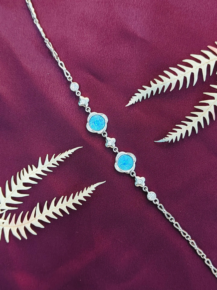Necklace with blue stones and silver chain on a purple fabric background