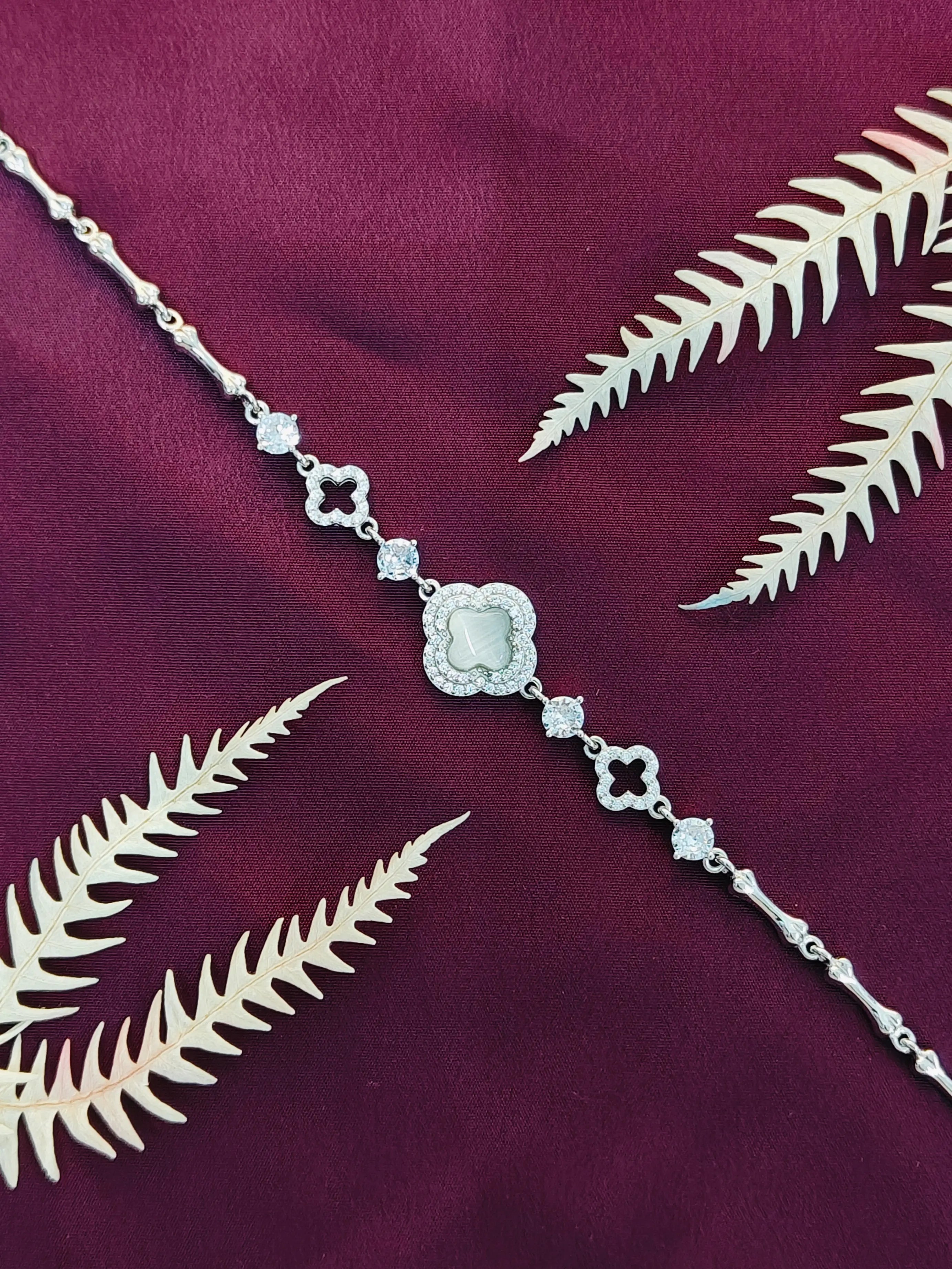 Silver bracelet with decorative clasp on a purple fabric background