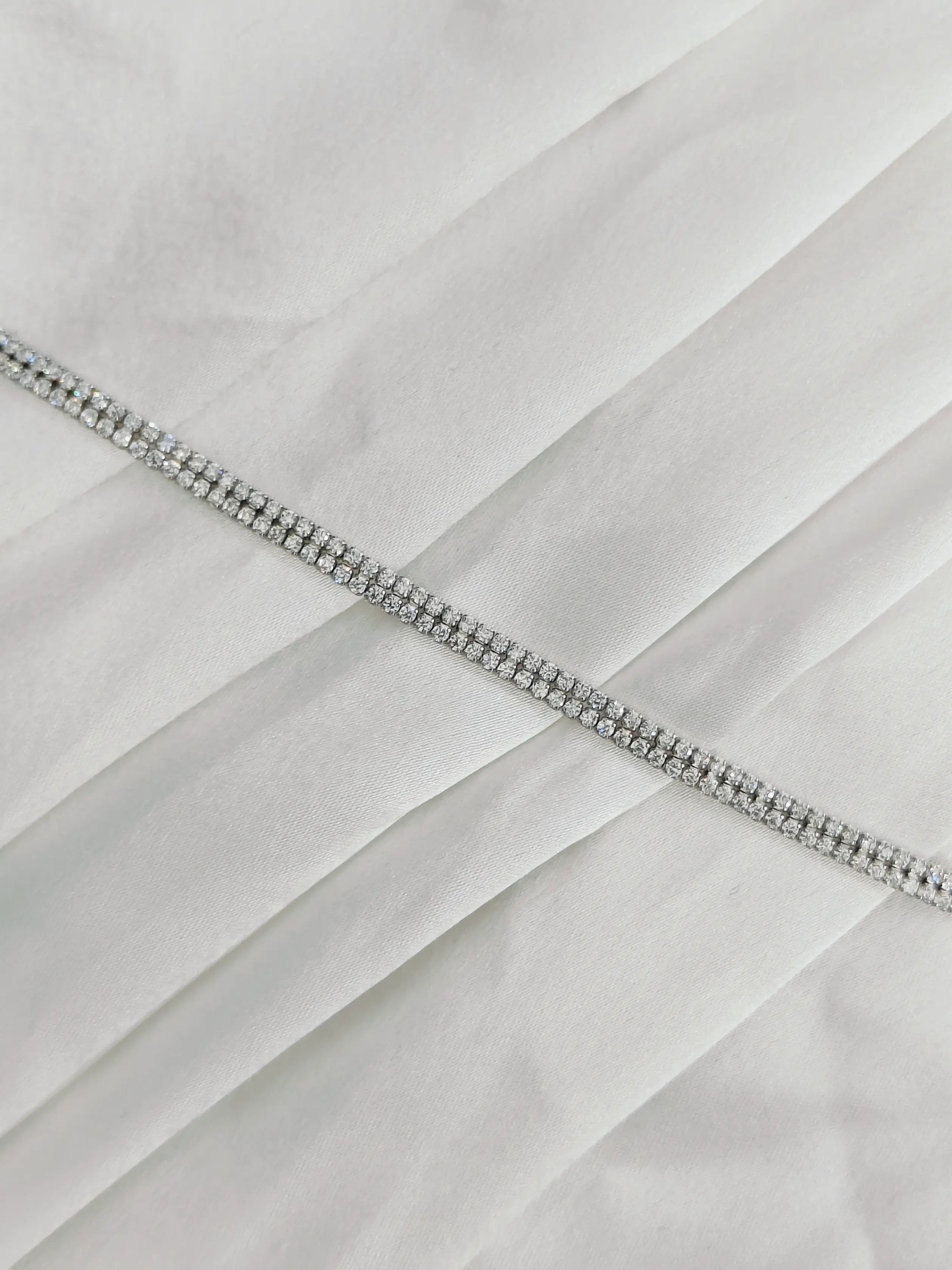 Close-up of a white fabric with a decorative silver zipper
