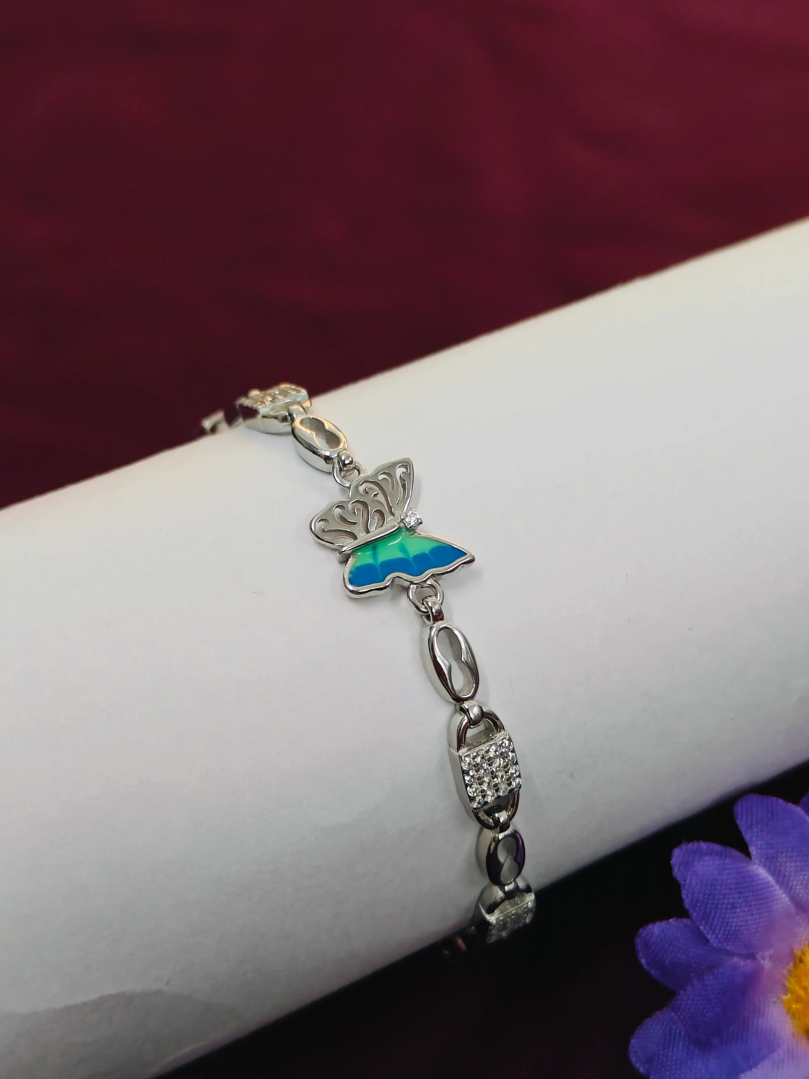 Silver bracelet with a butterfly charm on a white surface