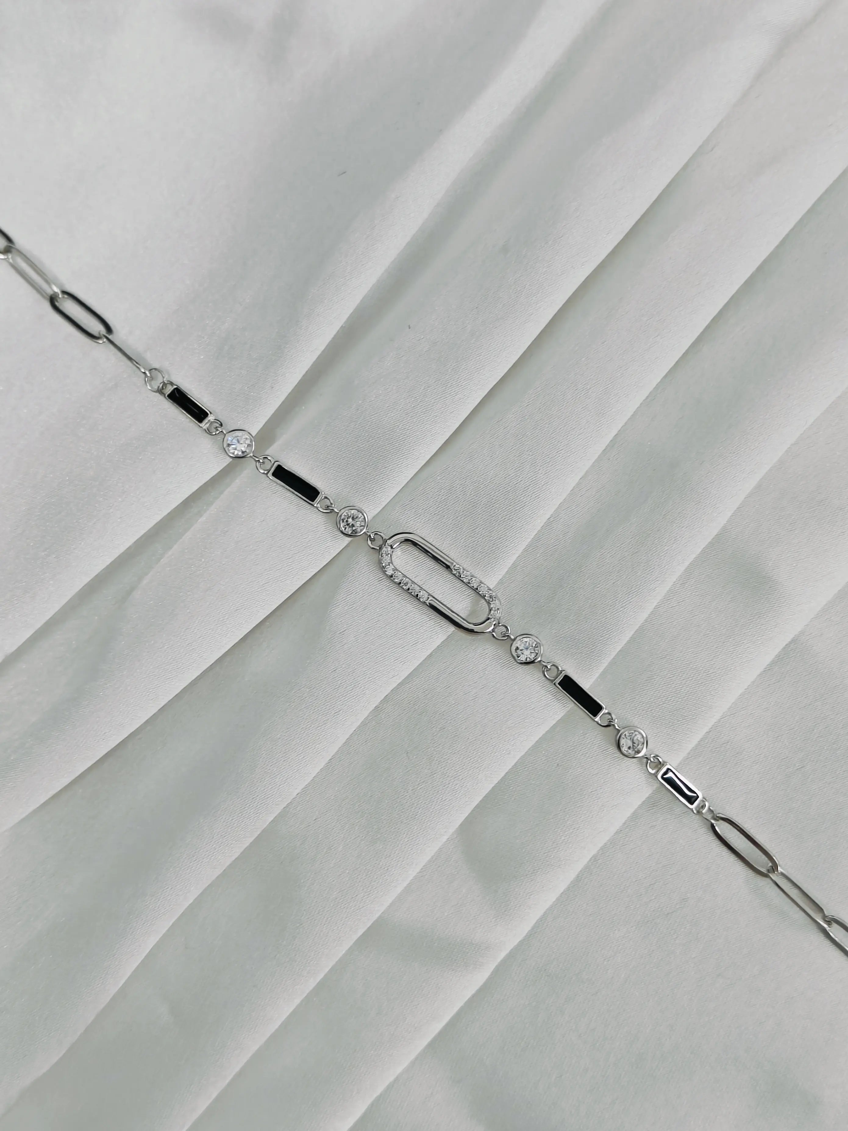 Silver bracelet with clear stones on a white fabric background