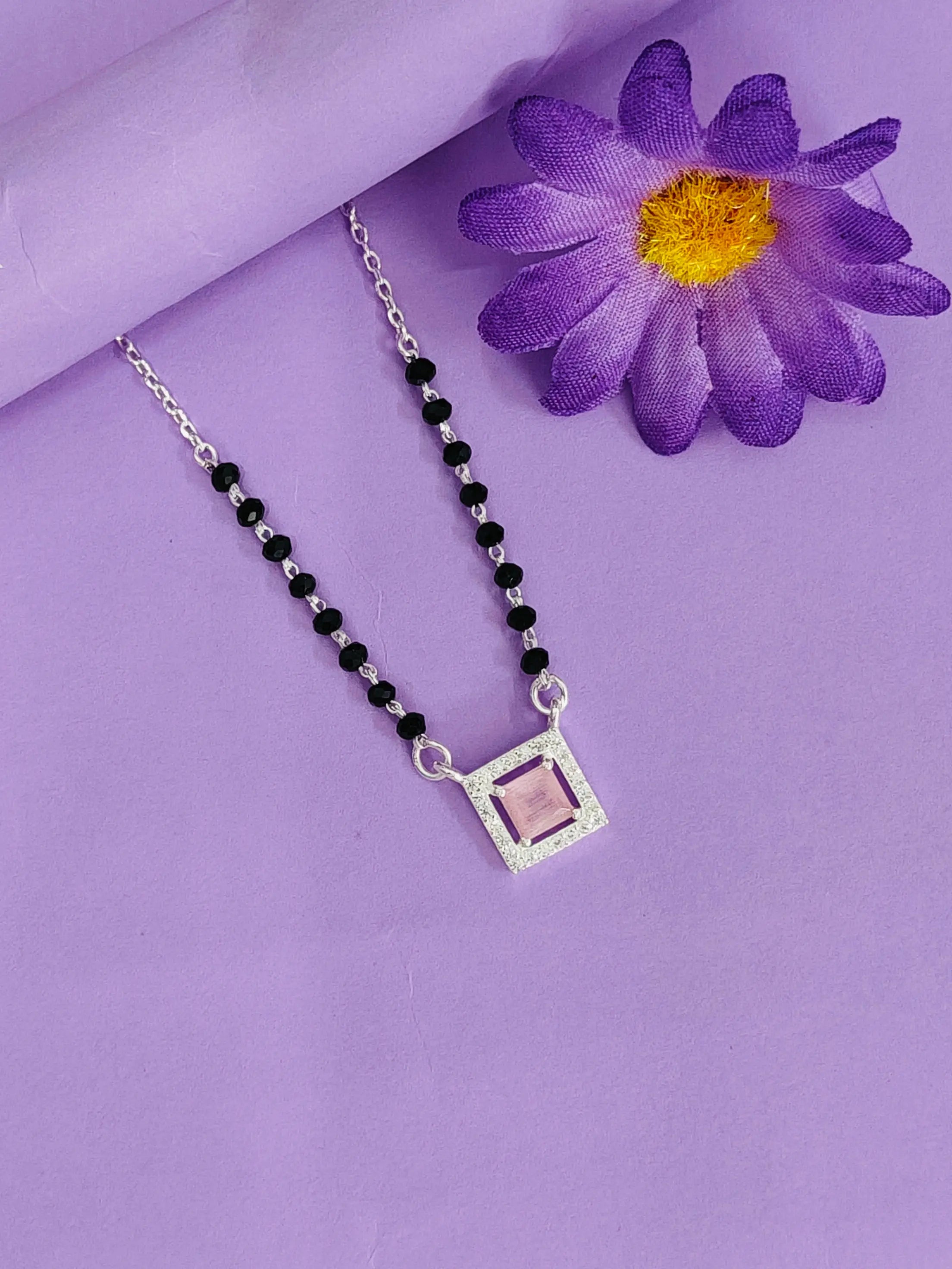 Necklace with a square pendant on a purple background with a purple flower