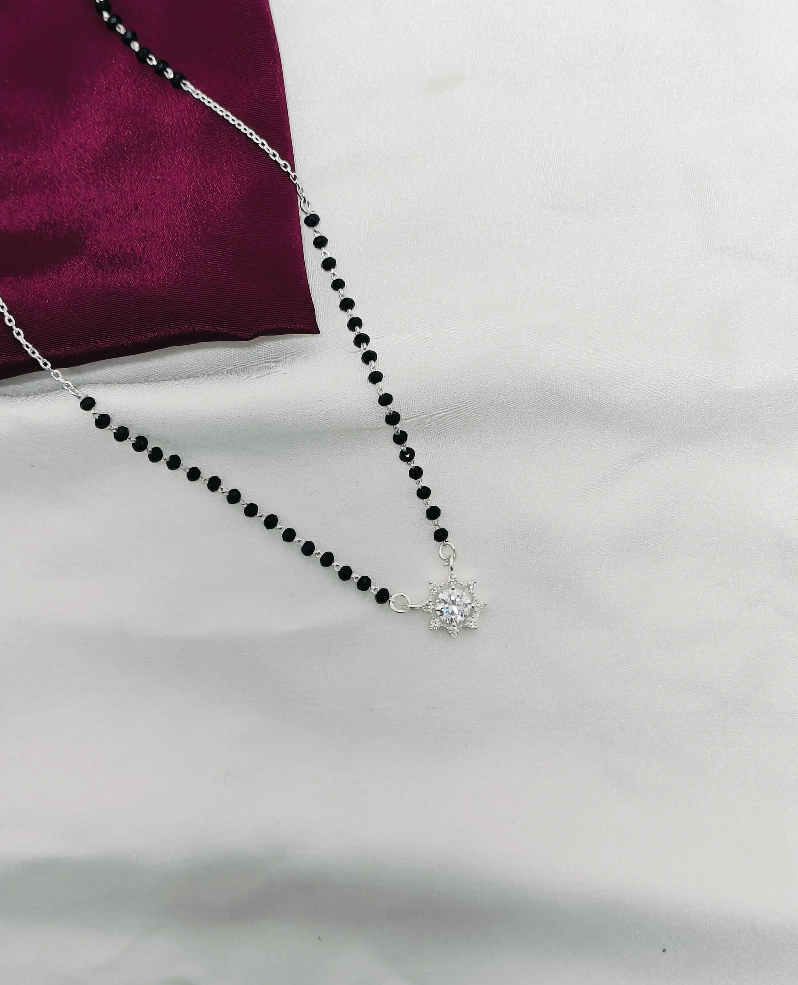 Necklace with black beads and a silver clasp on a white background