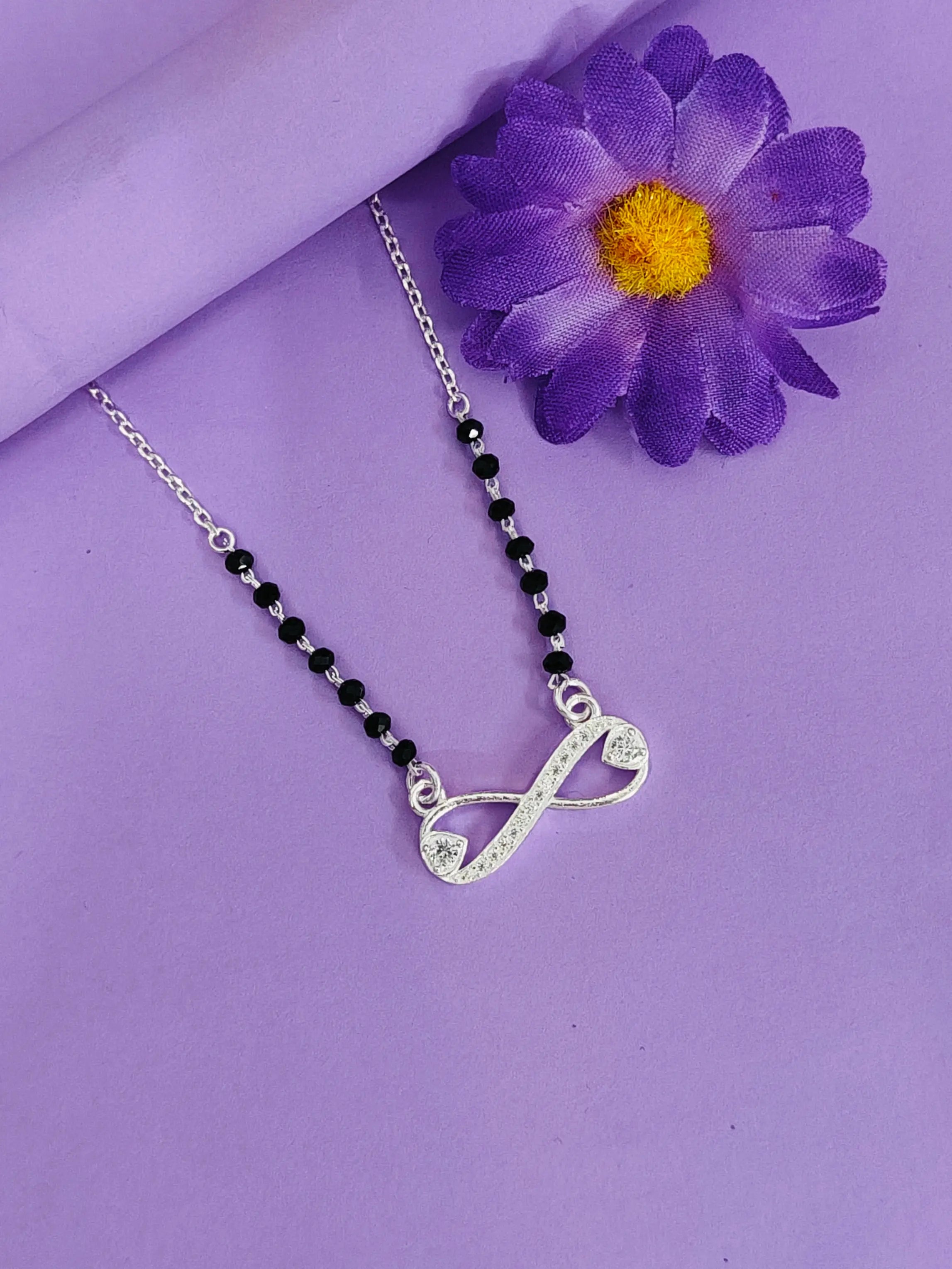 Necklace with a silver pendant on a purple background with a purple flower