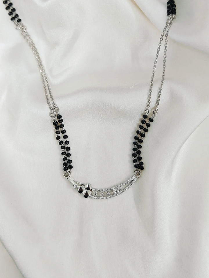 Necklace with black beads and silver chain on a white background