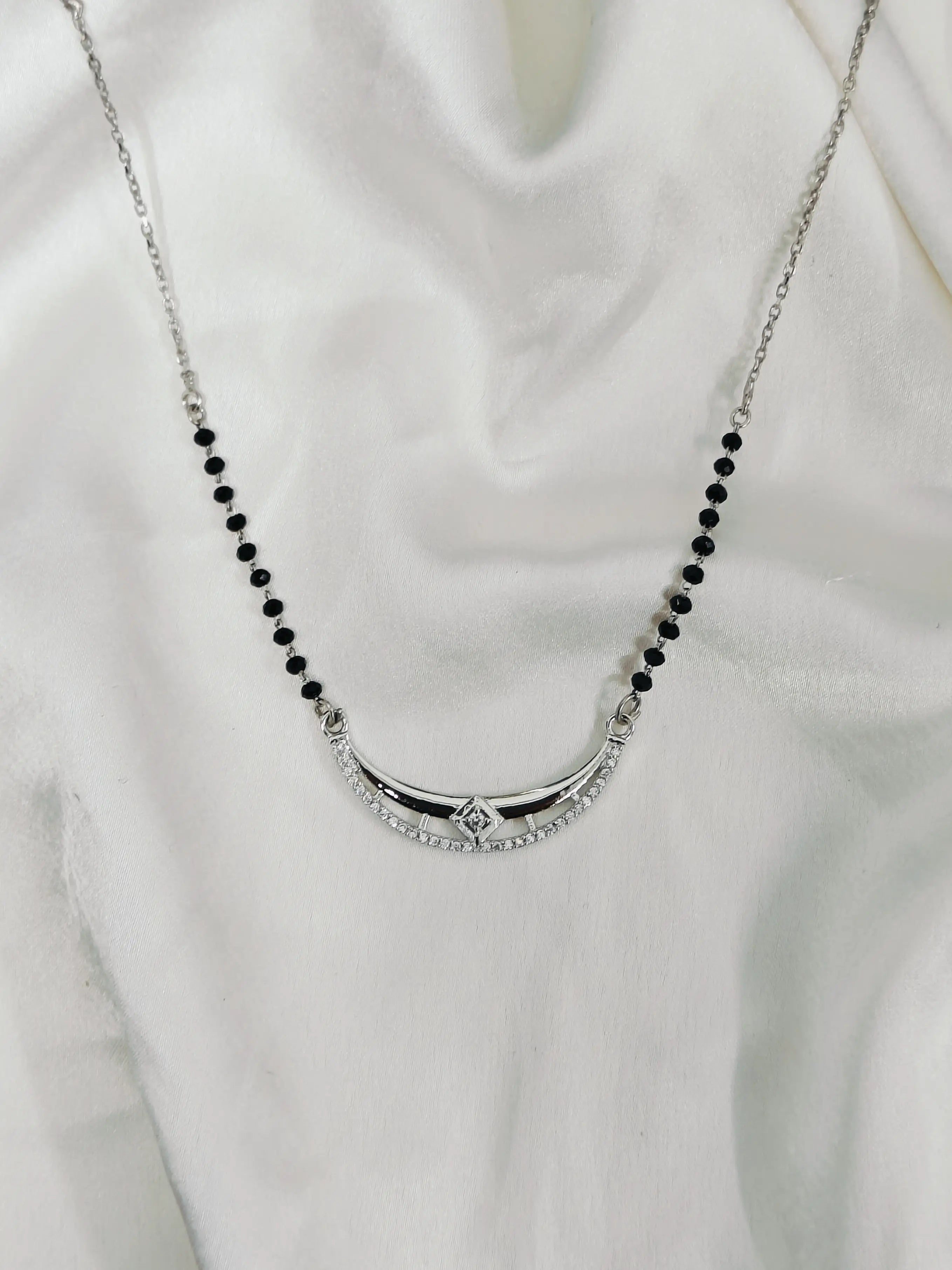 Necklace with black beads and a silver clasp on a white background
