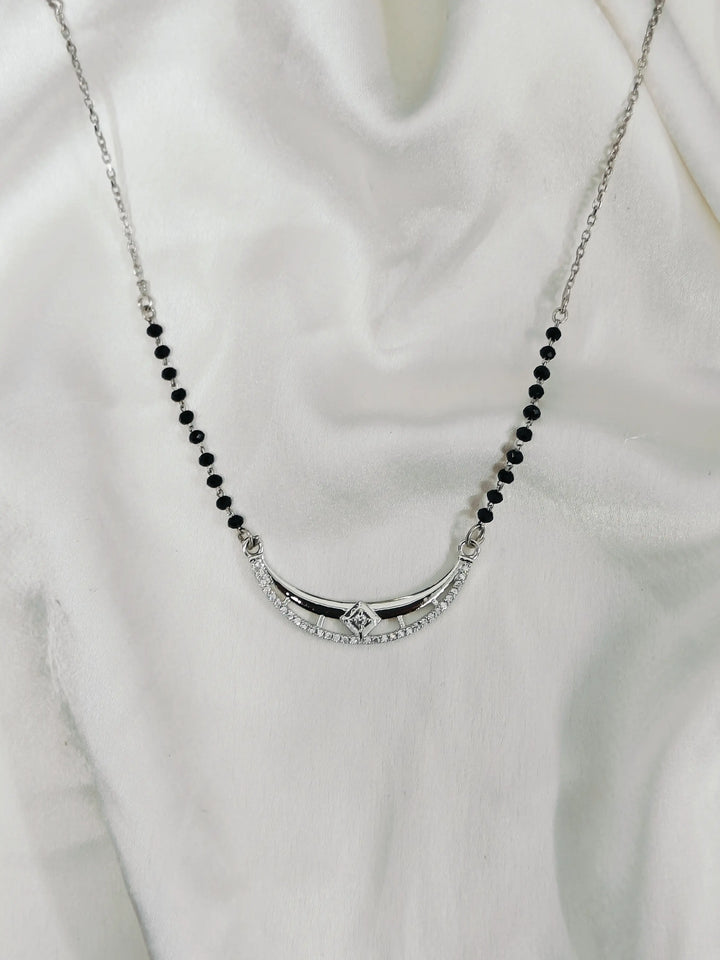 Necklace with black beads and a silver clasp on a white background