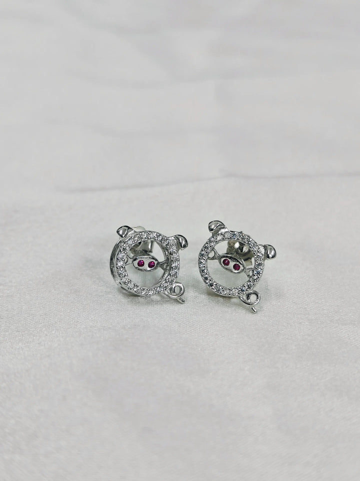 Pair of silver earrings with gemstones on a light gray background