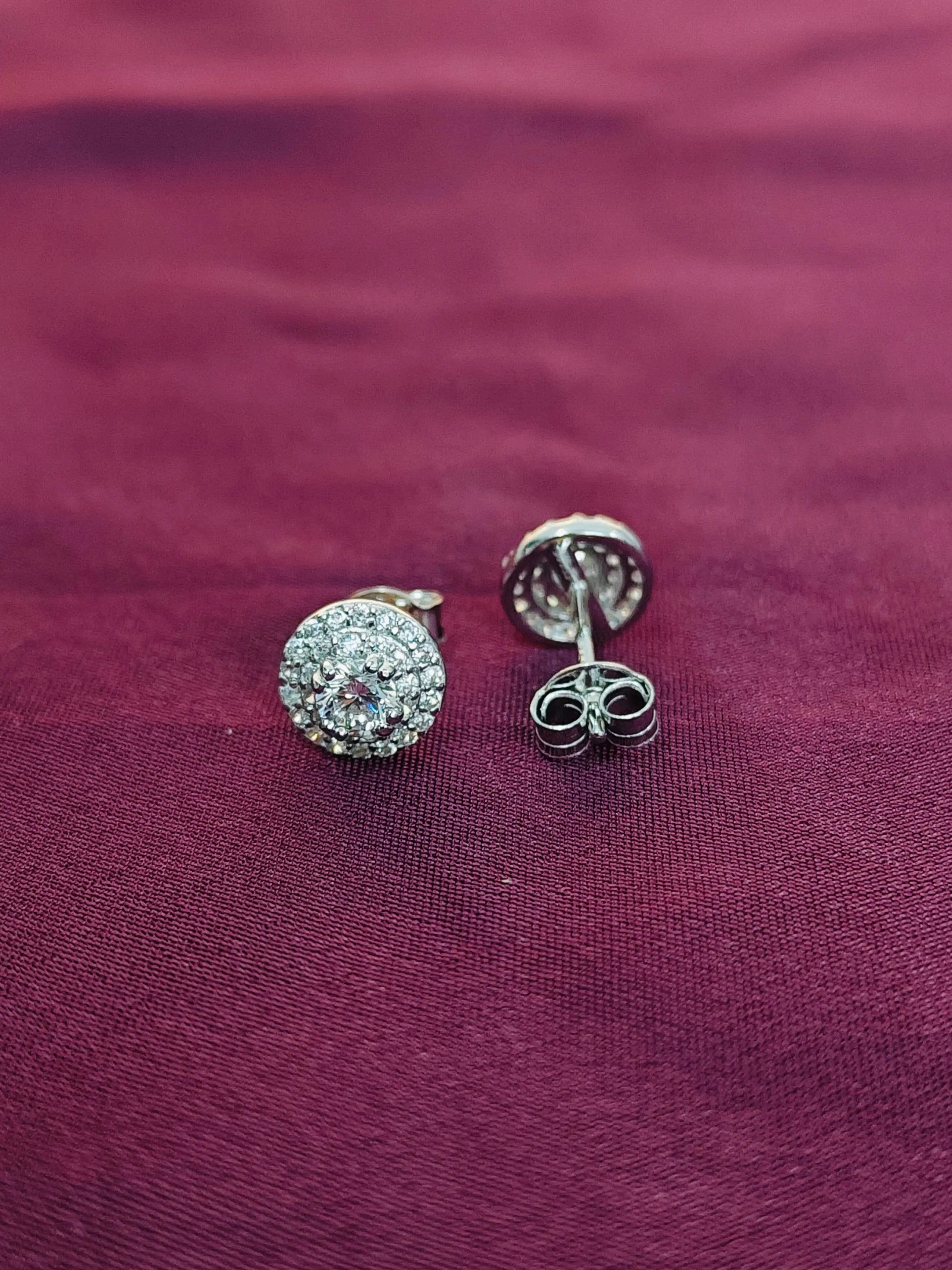 Silver earrings with gemstones on a purple fabric background