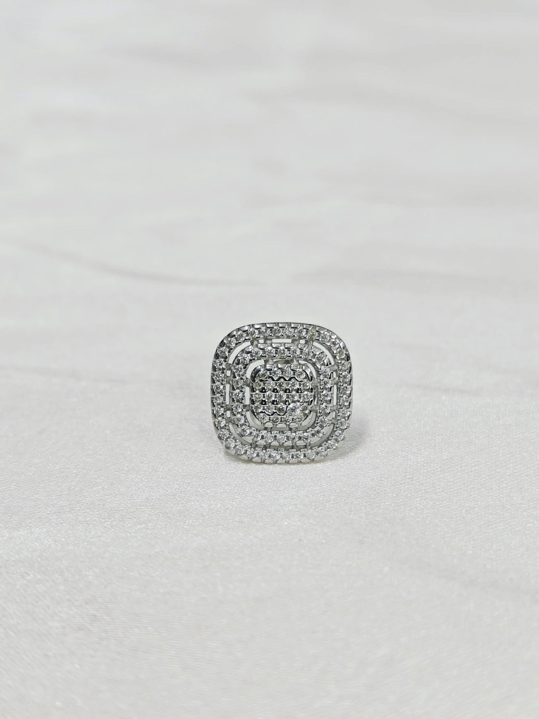 Silver ring with gemstones on a light gray background